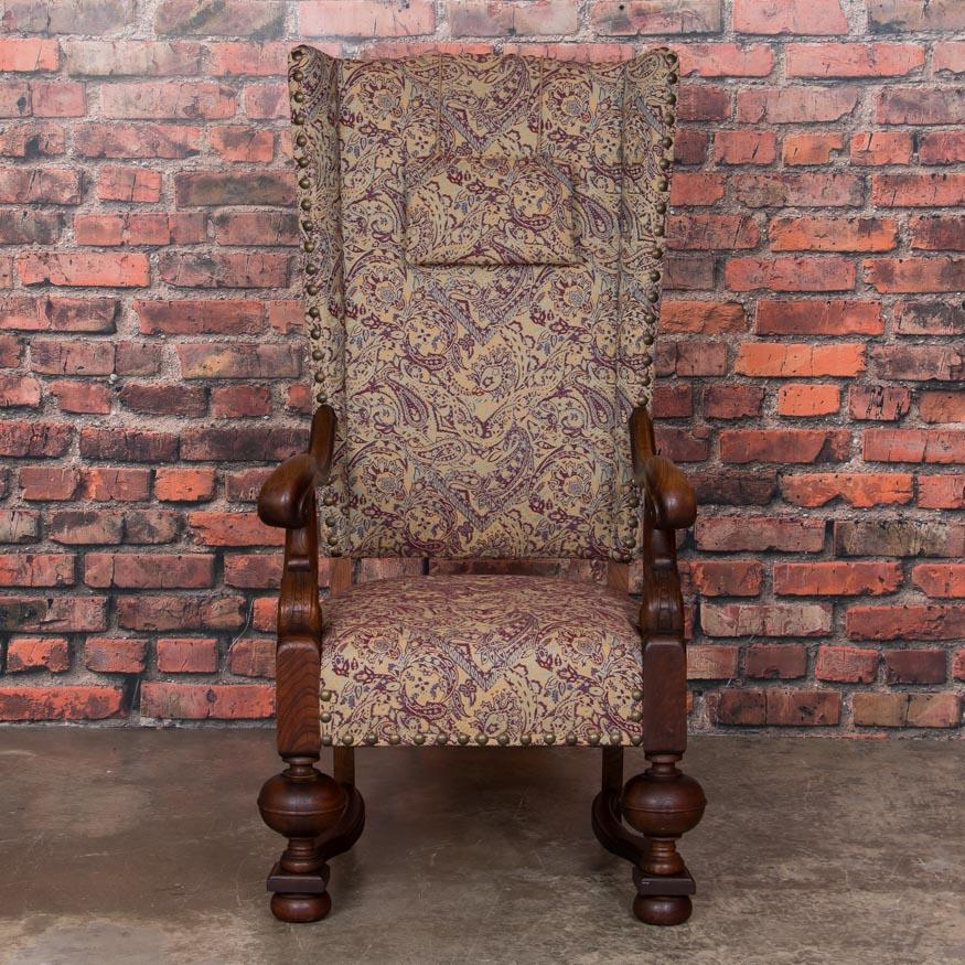 The high, straight back and exquisitely carved oak arms and turned legs distinguish this baroque wingback chair from others. The upholstery can easily be updated with a modern fabric of your choice to accent this dramatic arm chair. Take note of the