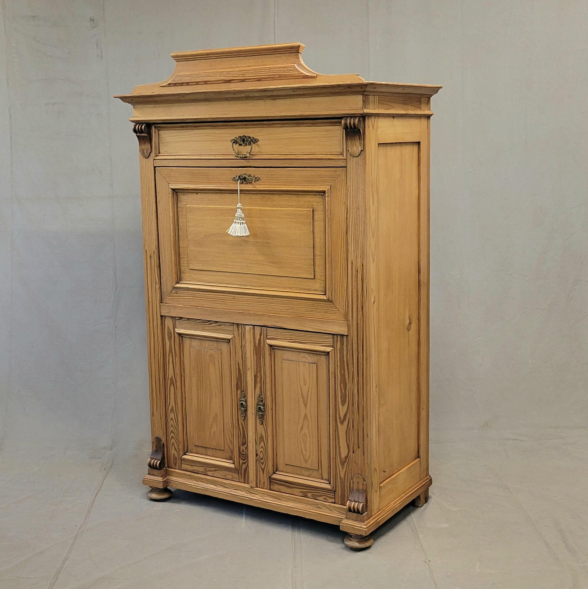 Un'imponente scrivania antica del 1900 circa in stile Biedermeier danese, realizzata in splendido pino a venatura diritta con ferramenta originale in ottone. Dall'alto verso il basso, la scrivania presenta un cassetto portaoggetti, una superficie