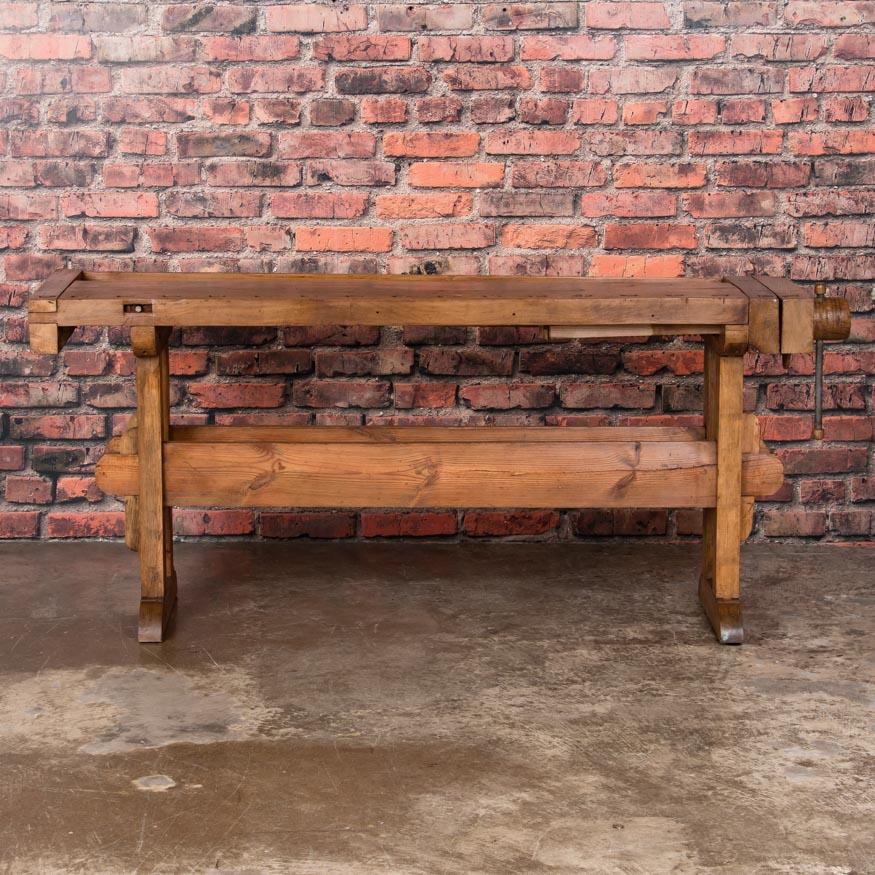 The wonderful wear and distressed wood from years of use add to the appeal of this circa 1900 workbench which features a working end vise and the original tool trough. The top is detachable and comes with a traditional trestle base that allows it to