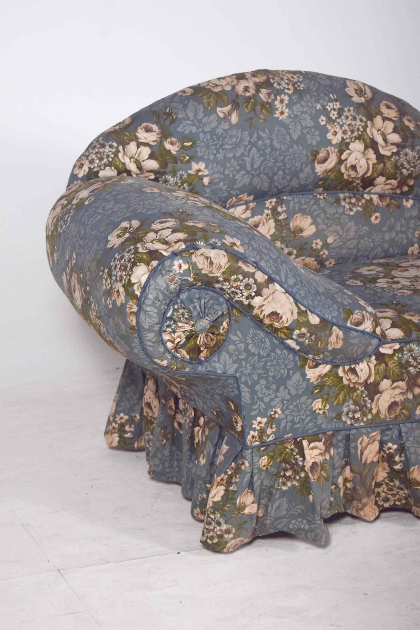 Chaiselongue en tissu bleu fleuri. Avec un dossier ondulé, plus haut à une extrémité et doucement abaissé à l'autre, il confère à la pièce une allure élégante et fluide, évoquant le confort et la sensualité associés au repos bourgeois.
Entièrement