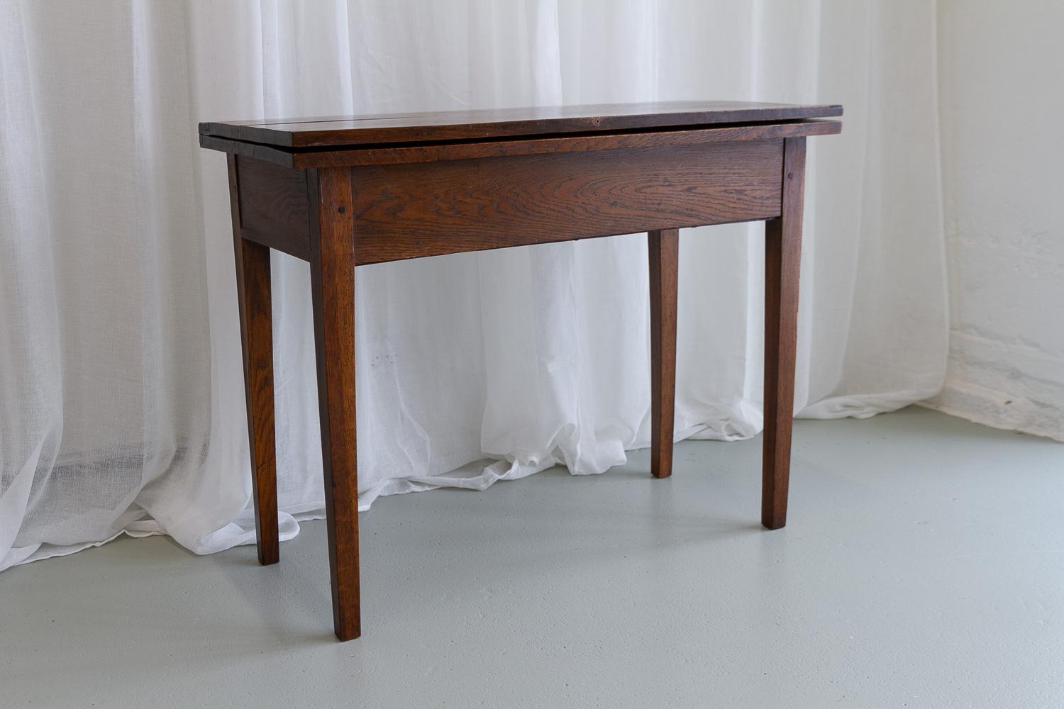 Antique Danish Console Table in Oak, Early 1800s.

200 years old charming and rustic Danish console table with flip top. Made in solid oak with hand carved wooden pegs and hand forged hinges and nails.

The tabletop can be turned to reveal hidden