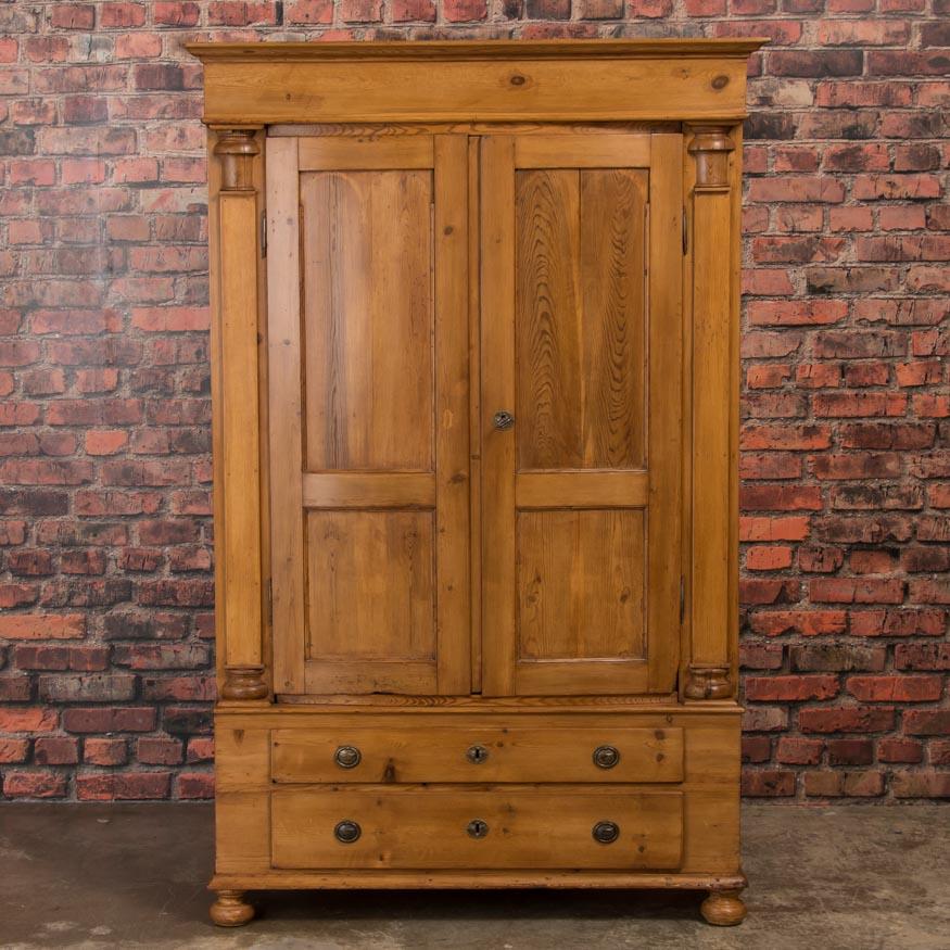 The striking beauty of this large country armoire is due to the graceful lines and curves enhanced by the warmth of the natural pine. Seen from any side, this armoire attracts the eye. This Biedermeier period piece was handcrafted circa 1840-1860 in