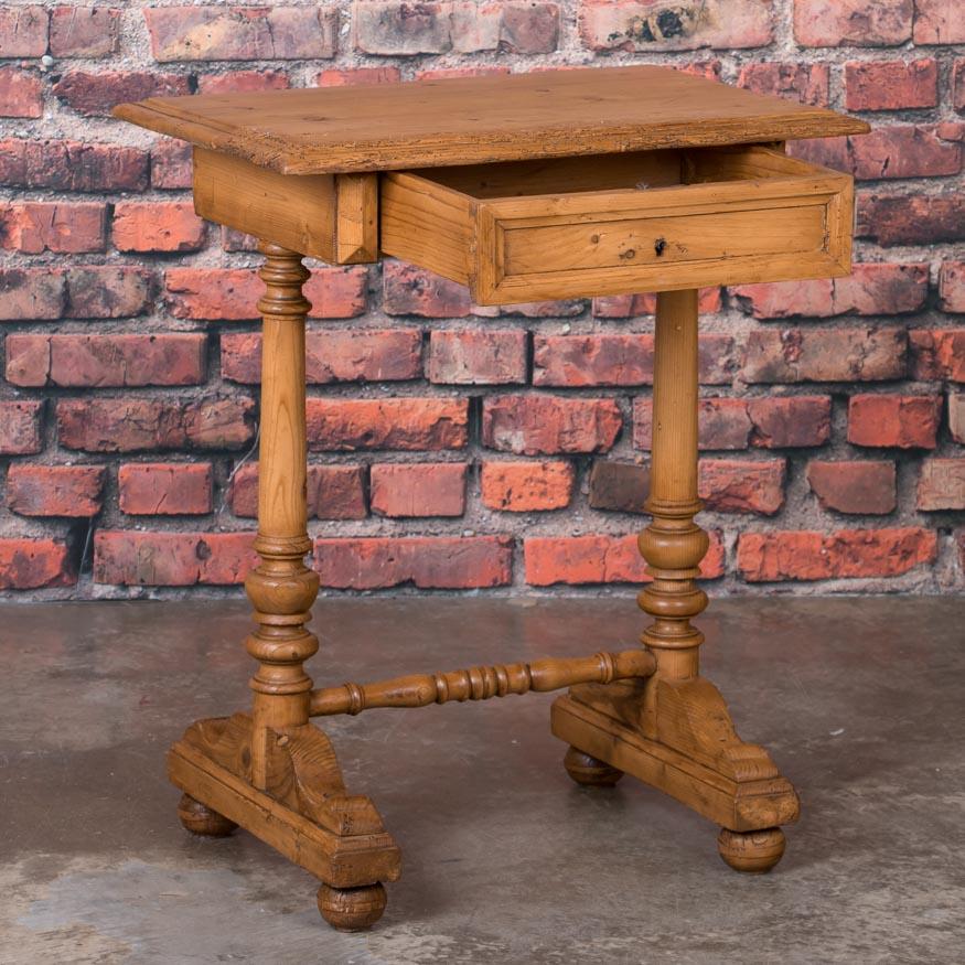 This versatile country pine table with it's unusual sculptural base, single drawer and small size would make a great side table or nightstand. The table has a wax finish which enhances the color and brings out the warmth of the natural pine. Please