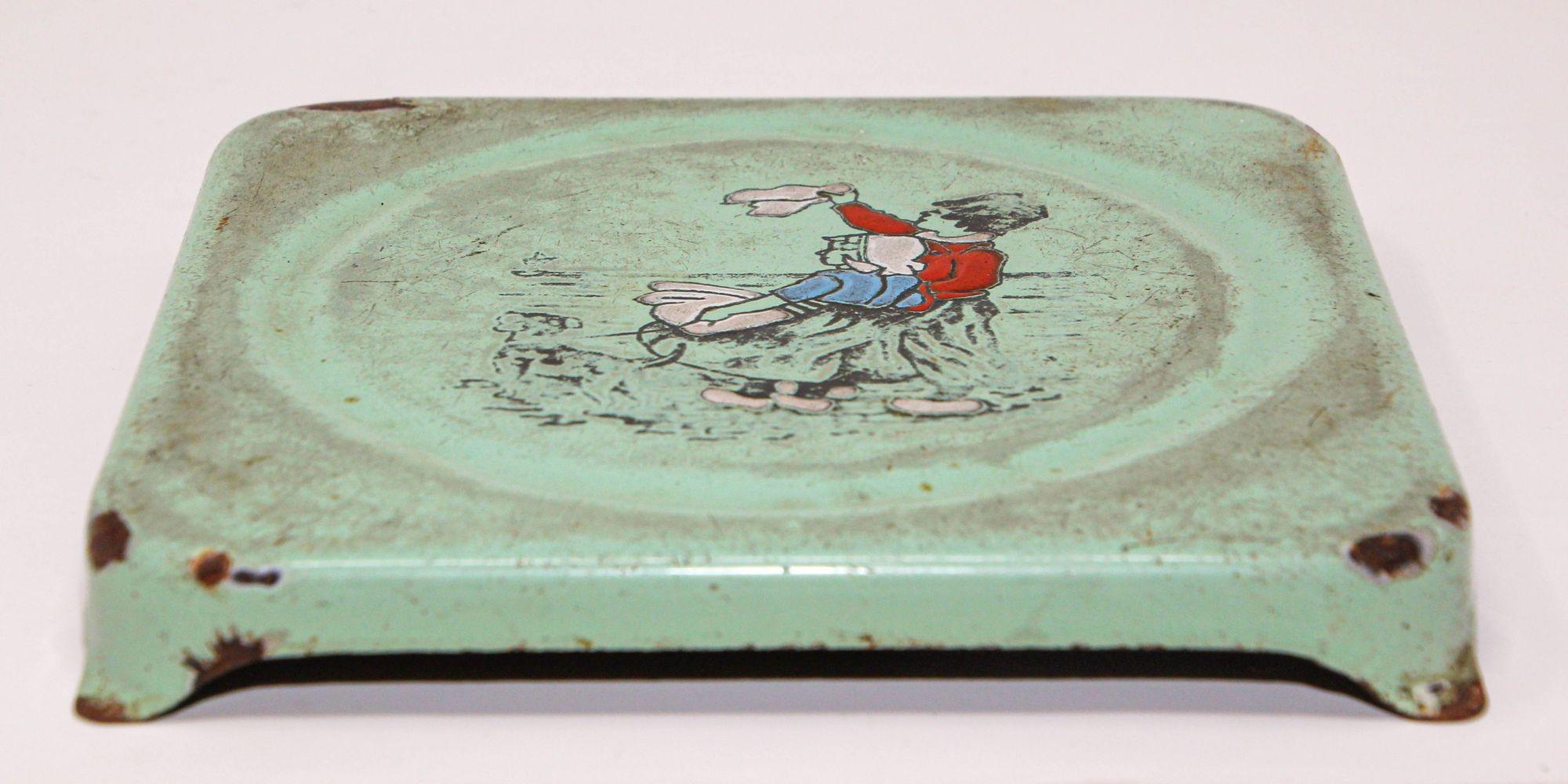 Antique early 20th century Hand Painted Dutch Theme Enamelware Metal trivet 1920's.
Hand-painted decorative antique Dutch scene metalware hand made In North Europe, Netherlands, Dutch or Germany featuring a Dutch man and women waiving goodbye.