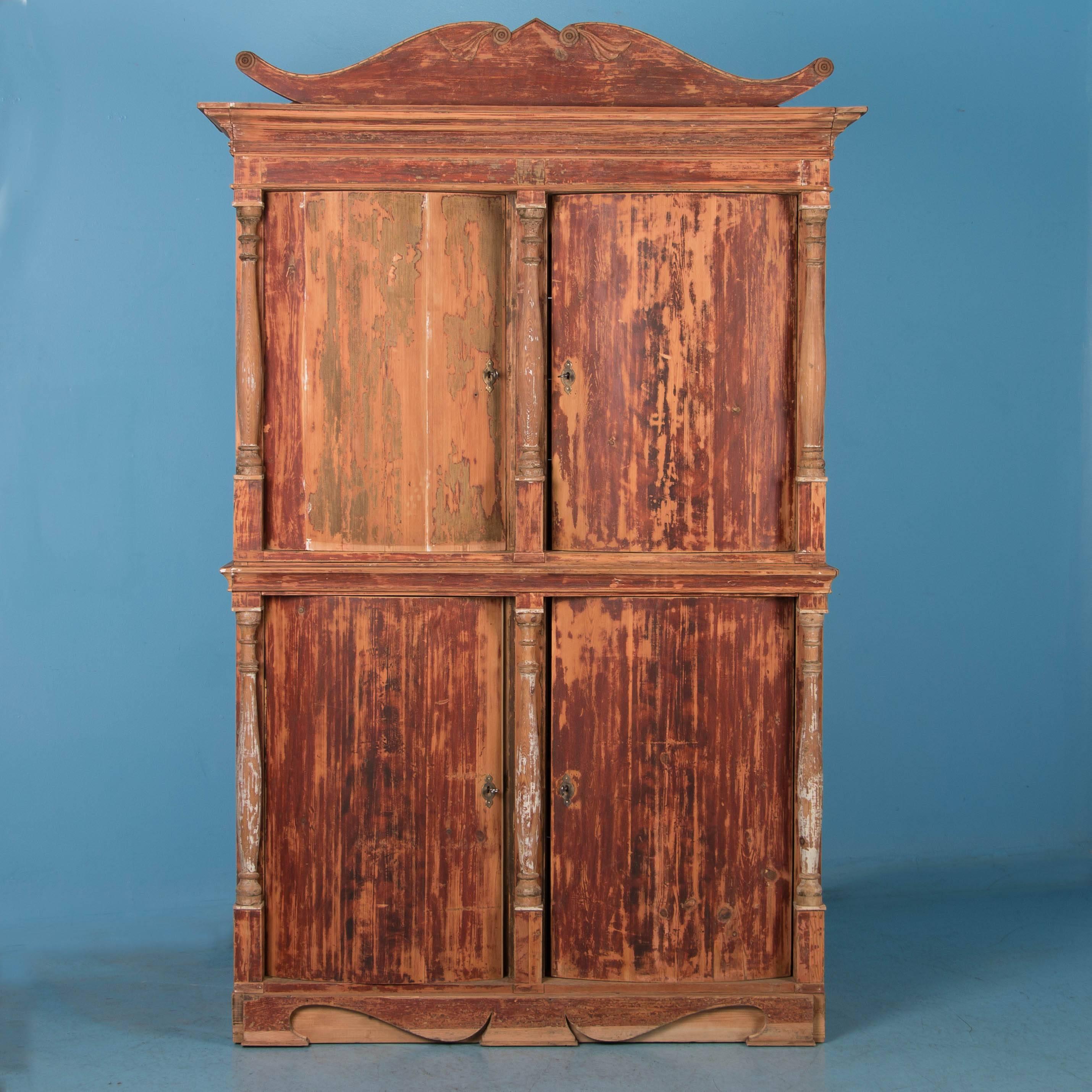 The great appeal of this remarkable cabinet is largely due to the original brick red paint, which has been scraped leaving a soft, raw feel to the finish. The six turned columns were originally painted white, now providing a subtle contrast to the