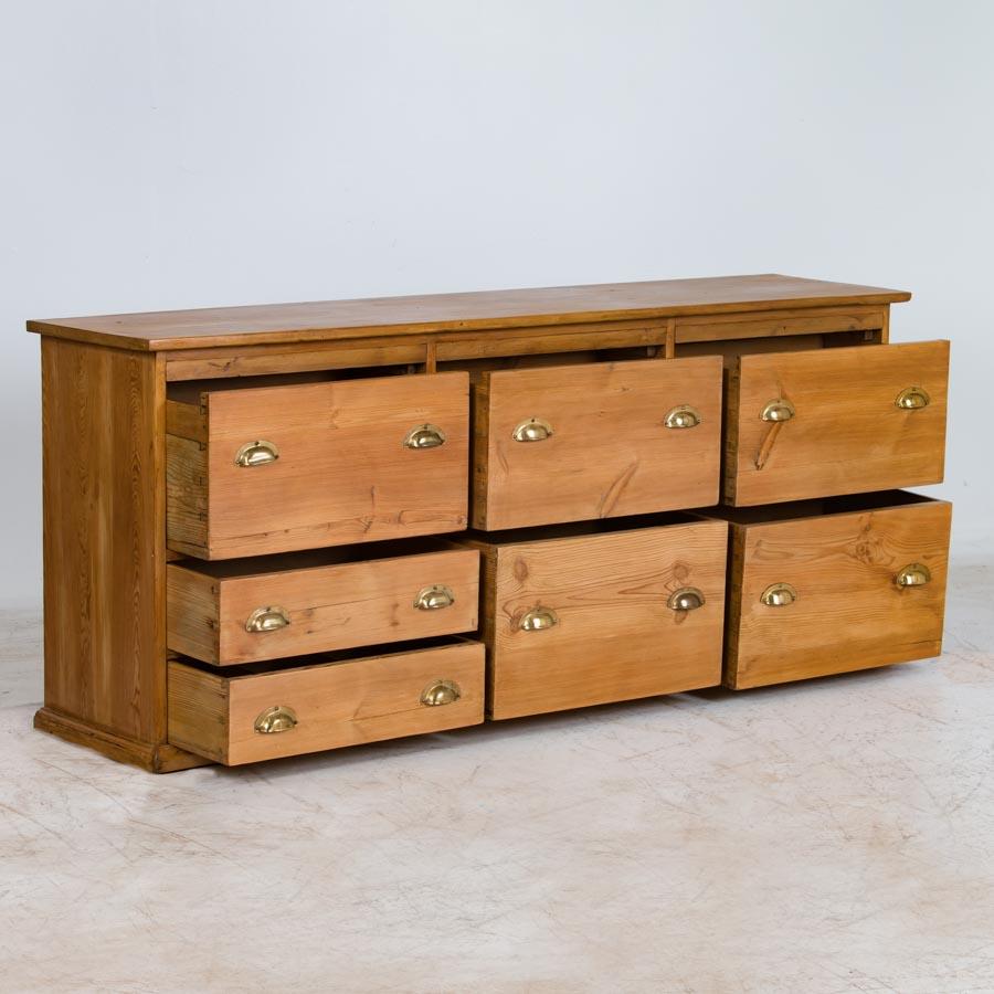 Loaded with character, this unique pine cabinet originally served as a grocer's shop counter or storage cabinet. Counters similar to this were used throughout shops in Europe during the 1800's, and are great finds today as a way to encorporate old