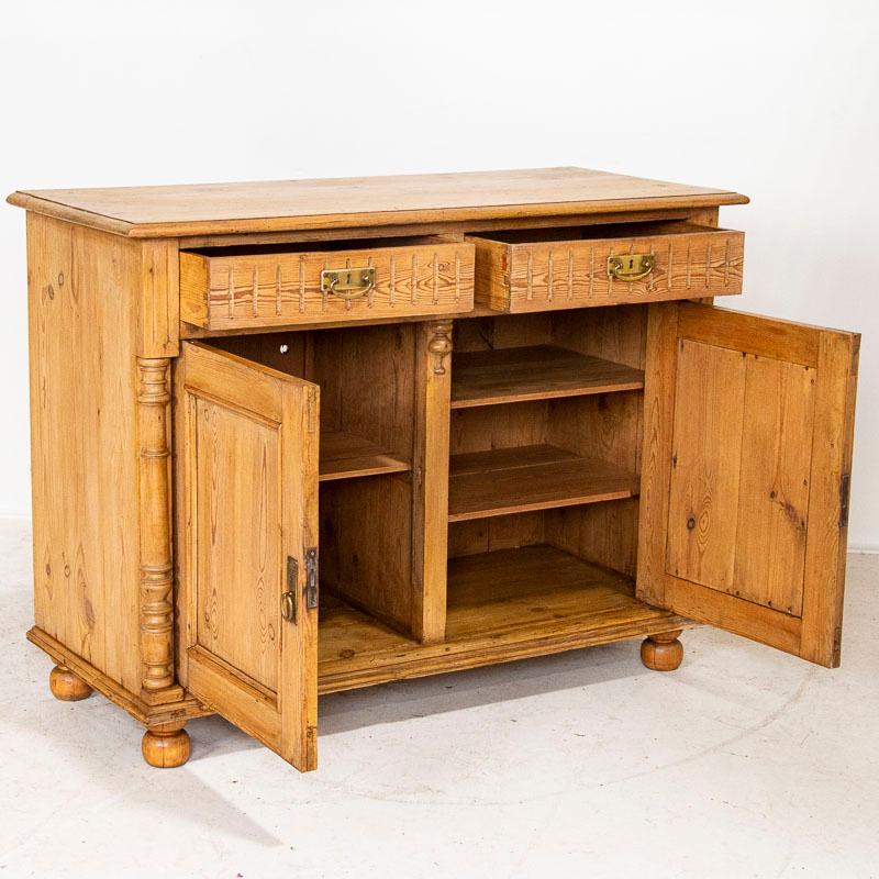 European country charm exudes from this pine sideboard from Denmark. The lovely turned half columns and carved detail to the top drawers add to the visual appeal of this cabinet. It has been restored and given a wax finish, bringing out the warmth