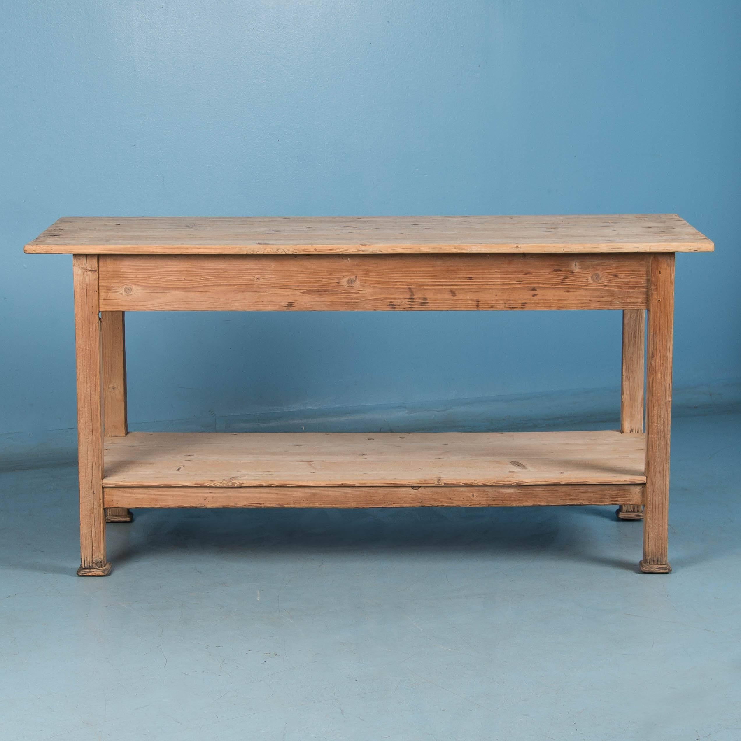 This rustic country pine table with a large work surface and a full lower shelf, would make a great kitchen island. The stripped pine has been left natural, giving this work table a more rustic or country feel, however a painted or wax finish could