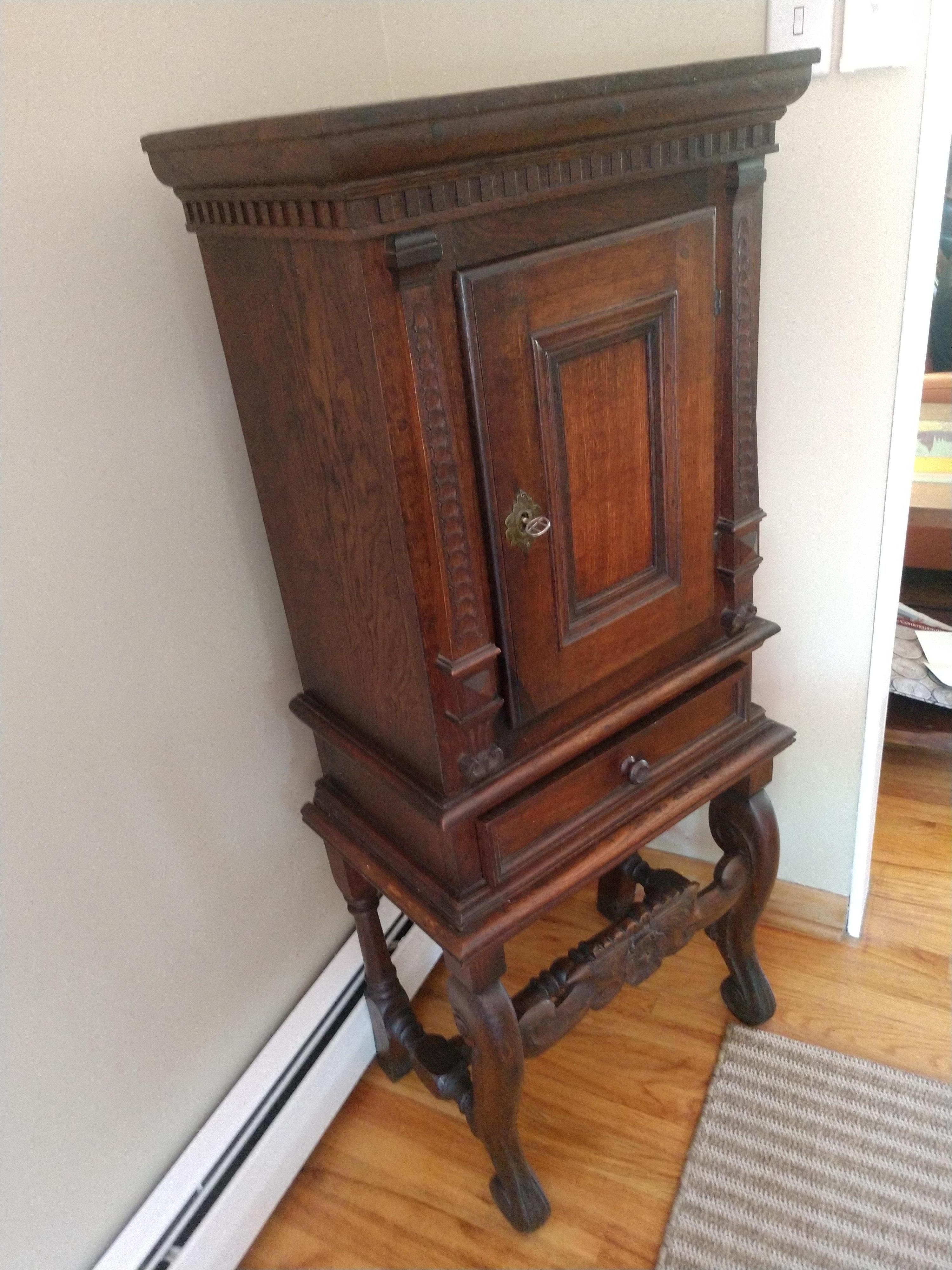 Hand crafted cabinet on a carved base with storage compartment up top. Created out of beautiful walnut, cabinet can serve many uses and functions today. Would work well in the bath or an office and dining room. In excellent vintage condition with