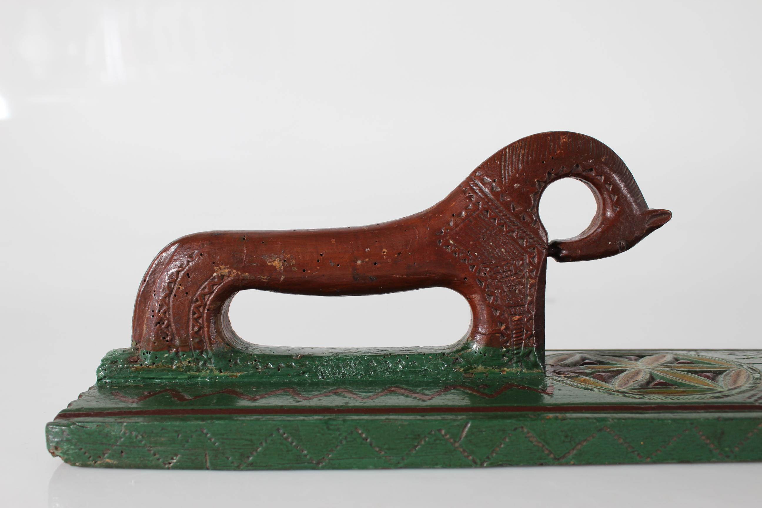 Dänisches Mangelbrett (Kleider- und Bettzeugpresse) von 1768.

Hergestellt aus Holz, reich verziert mit handgeschnitzten geometrischen Mustern und einem Pferd als Griff. Mit originaler brauner, grüner und ockerfarbener Farbe.
Die Verzierung zeigt
