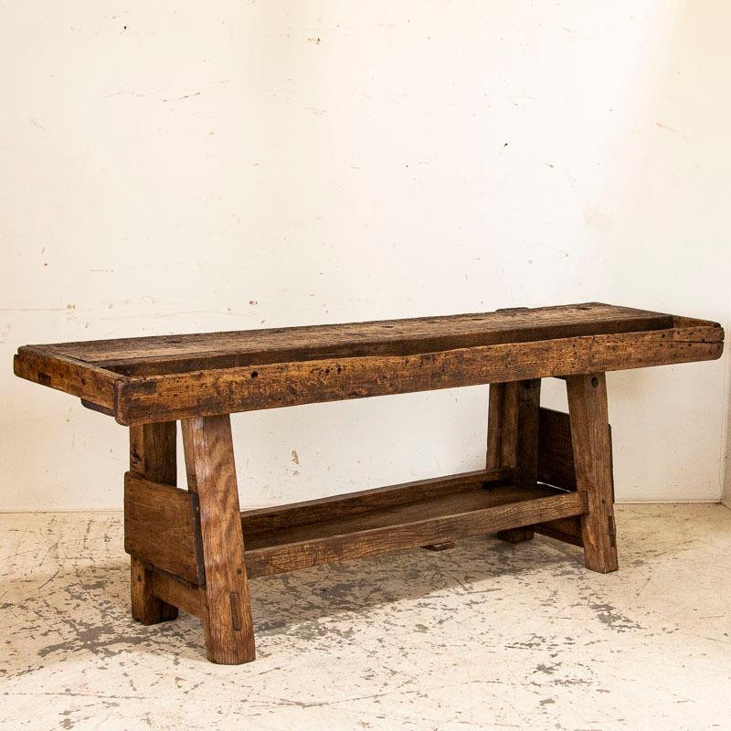 It is the years of constant use revealed in every ding, deep gouge, stain and scratch that enrich the character of this heavily distressed carpenters' workbench from France. Work tables such as this make a remarkable console table in a contemporary
