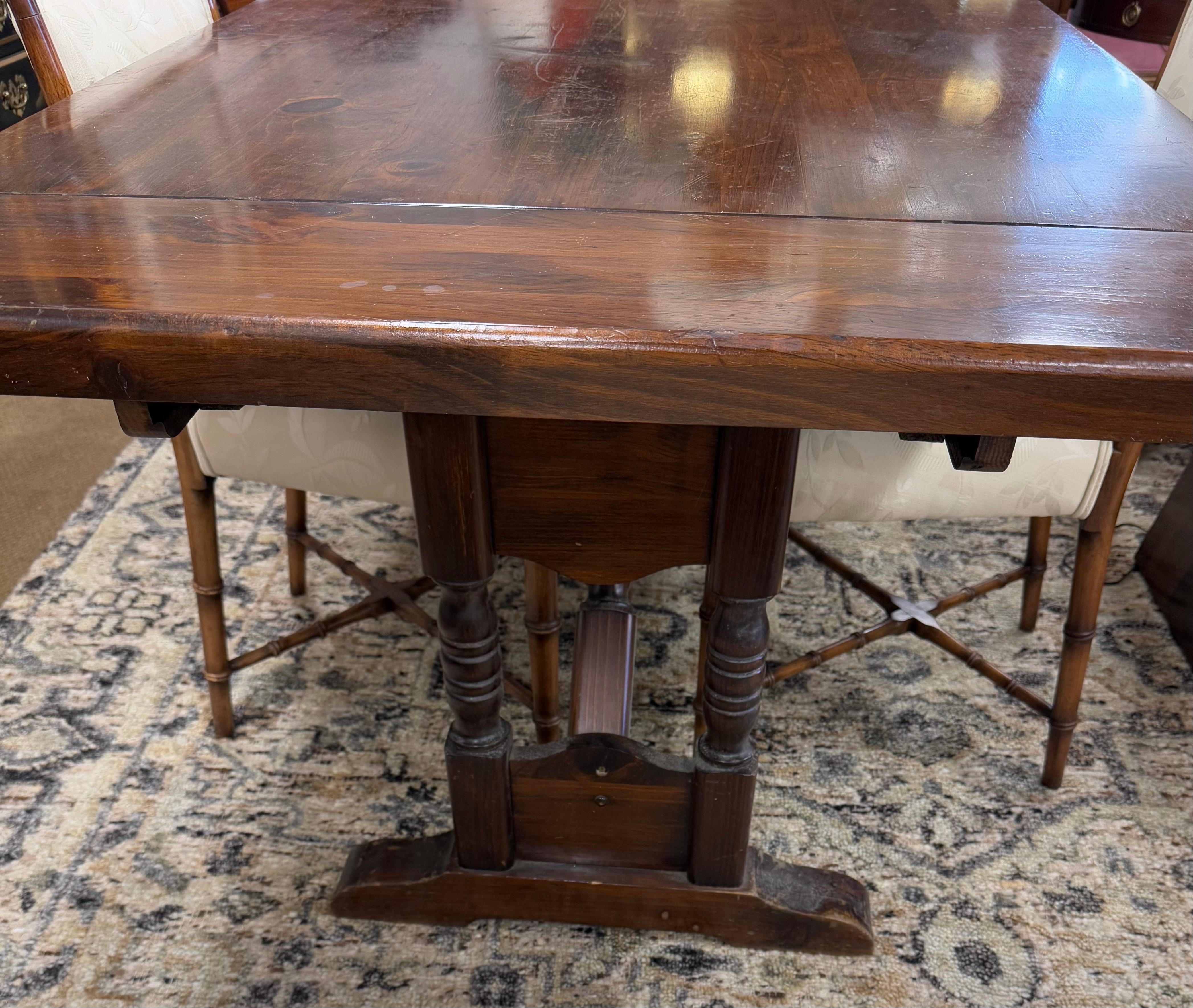 Exquisite trestle farmhouse antique dark pine wine tasting or dining table that extends with its two leaves.  Very solid and crafted from dark pine.  Each leaf extends the table by 15