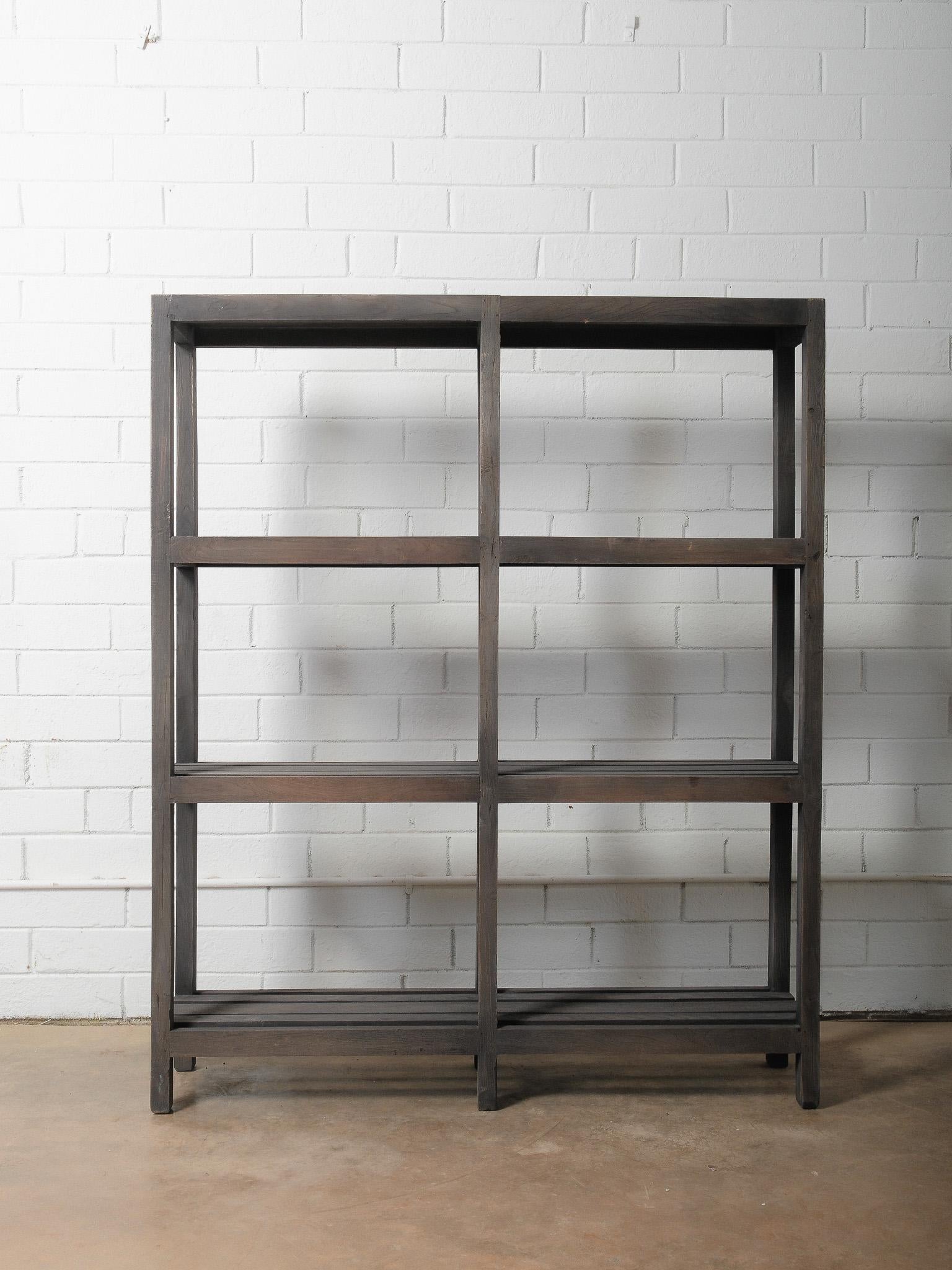 A beautifully weathered wooden shelf featuring a deep, charcoal-toned stain and an open slatted design. This handcrafted piece showcases simple, functional construction with visible joinery, timeworn edges, and naturally aged wood grain throughout.
