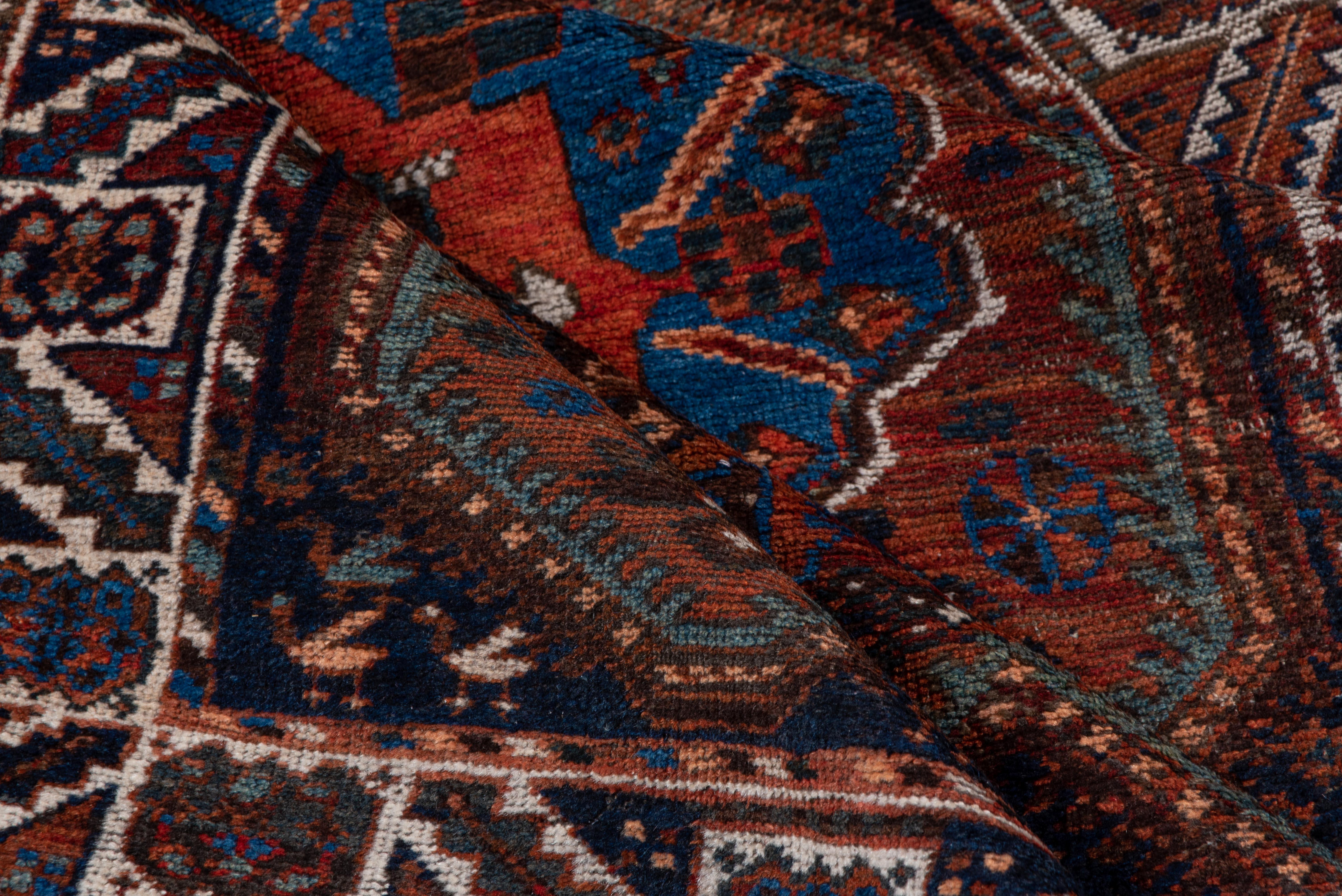 Ce tapis Shiraz (3,9 x 5,1) est un exemple frappant de tissage tribal persan, avec un médaillon central audacieux entouré de motifs géométriques complexes. Réputés pour leur riche héritage culturel, les tapis de Shiraz sont célébrés pour leur charme