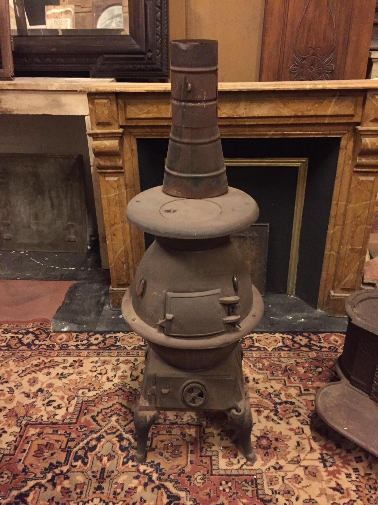 Antique dark brown wrought iron stove, typically from Italian valleys, suitable for rustic and mountain environments, small in size, adapts to any interior, manufactured in the 1900s, it is perfectly functioning to be connected with a suitable pipe.