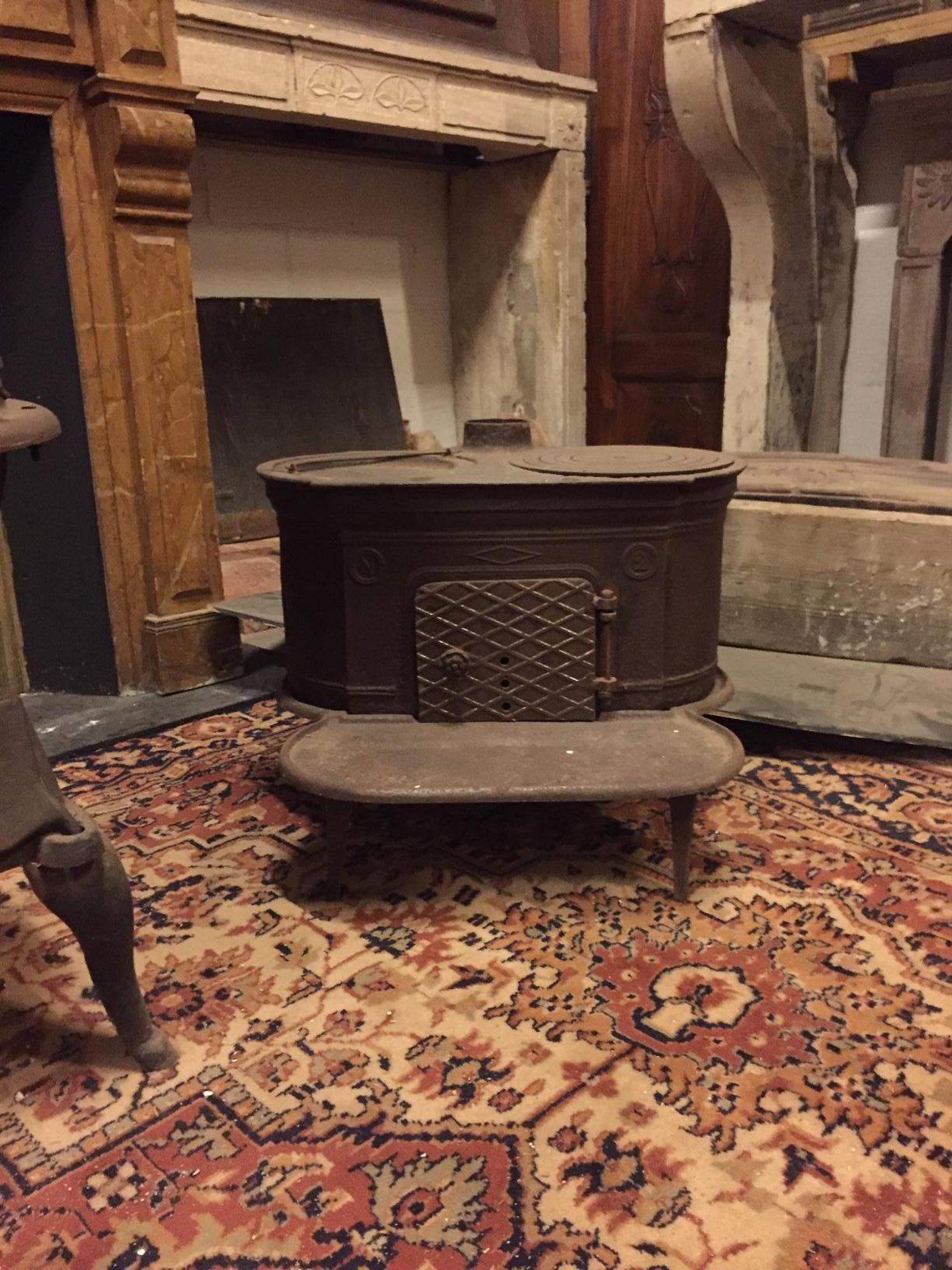 Antique dark brown wrought iron stove, typically from Italian valleys, suitable for rustic and mountain environments, small in size, adapts to any interior, manufactured in the 1900s, it is perfectly functioning to be connected with a suitable pipe.