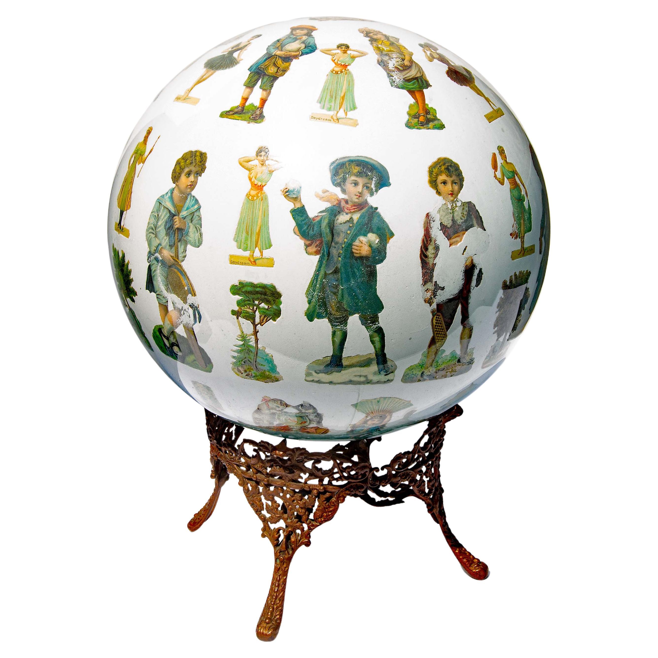 Antique decalcomania or potichomania large blown glass ball sphere. Hand blown glass sphere. 19th century cut out chromolithographs decoupaged into the interior. Amazingly through a 3/4