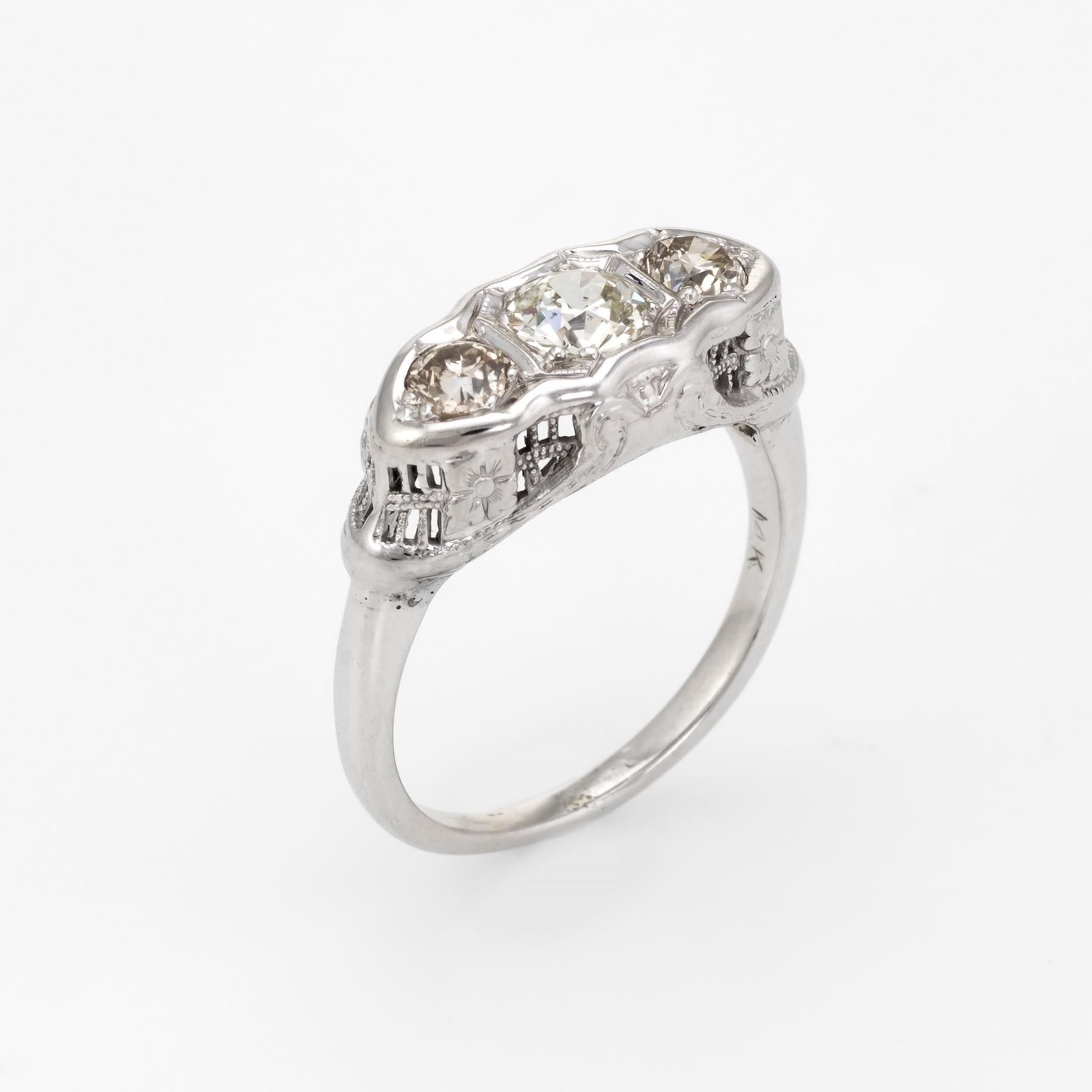 Finely detailed vintage Art Deco era 3 stone diamond ring (circa 1920s to 1930s), crafted in 14 karat white gold. 

Centrally mounted estimated 0.45 carat old European cut diamond is accented with two estimated 0.15 carat old European cut diamonds.