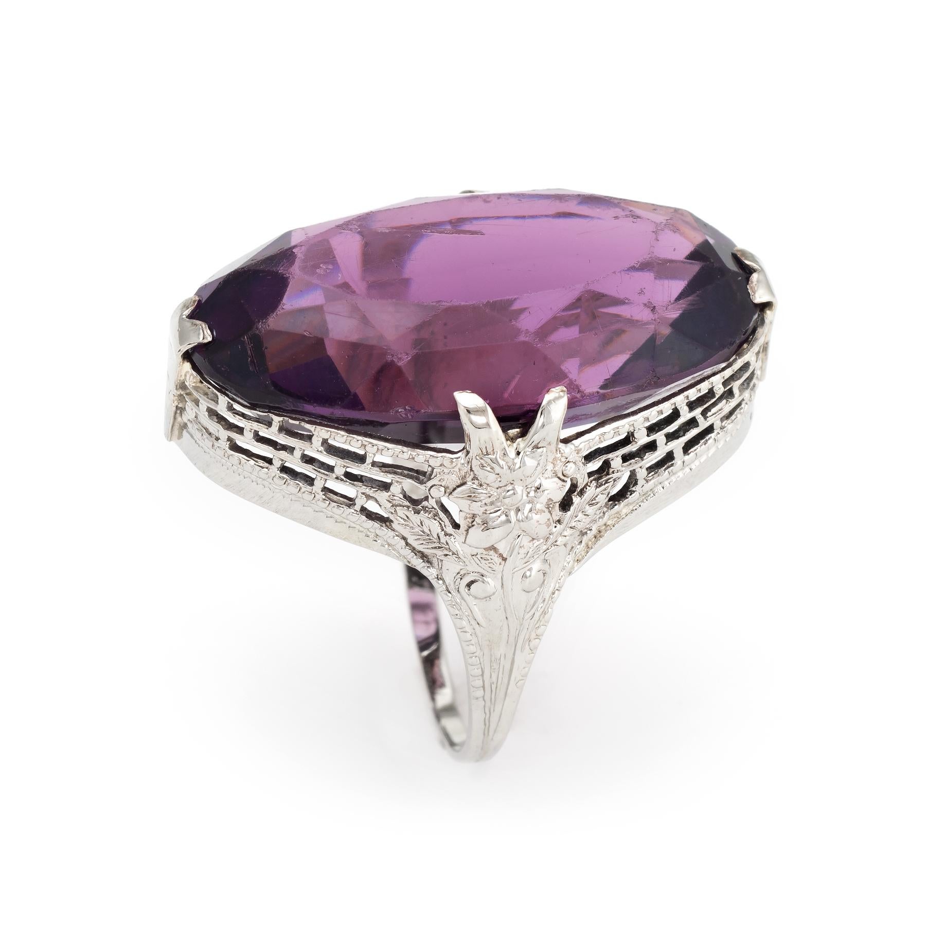 Finely detailed vintage Art Deco era cocktail ring (circa 1920s to 1930s), crafted in 10 karat white gold. 

Centrally mounted amethyst glass measures 23mm x 15mm (estimated at 25 carats). The amethyst is in good condition with wear evident (light