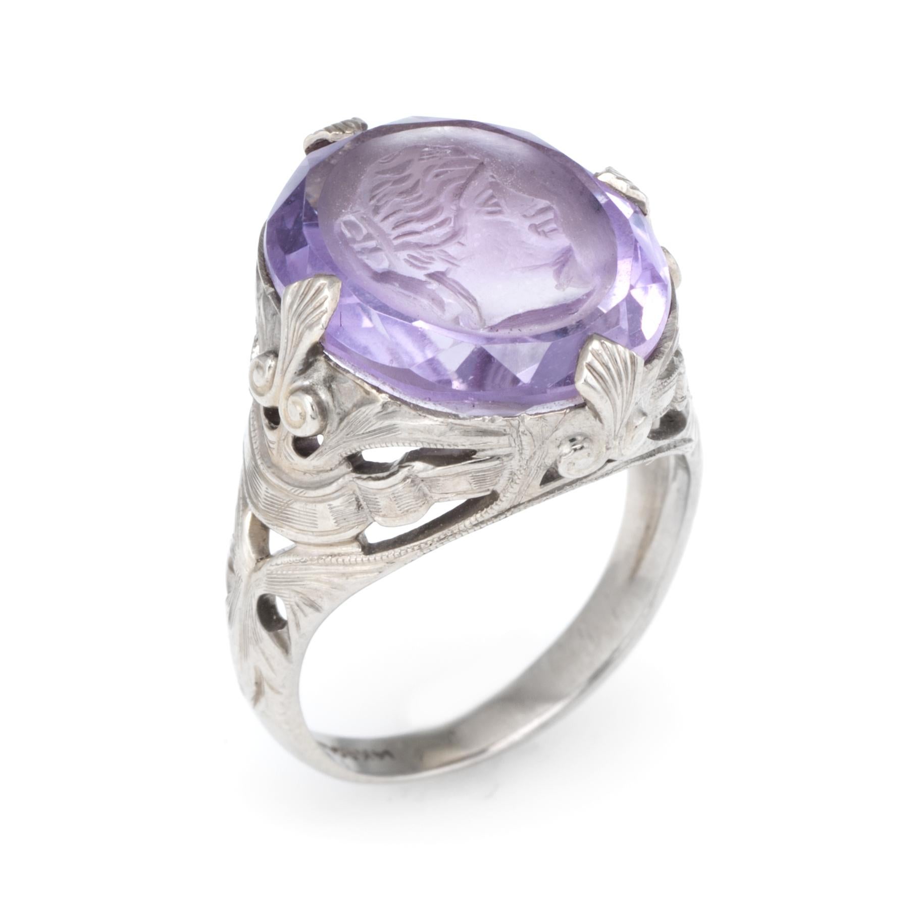 Finely detailed vintage Art Deco era ring (circa 1920s to 1930s), crafted in 14 karat white gold. 

Centrally mounted amethyst intaglio is carved featuring the head of a woman. The amethyst measures 16mm x 11mm (estimated at 8 carats). The amethyst