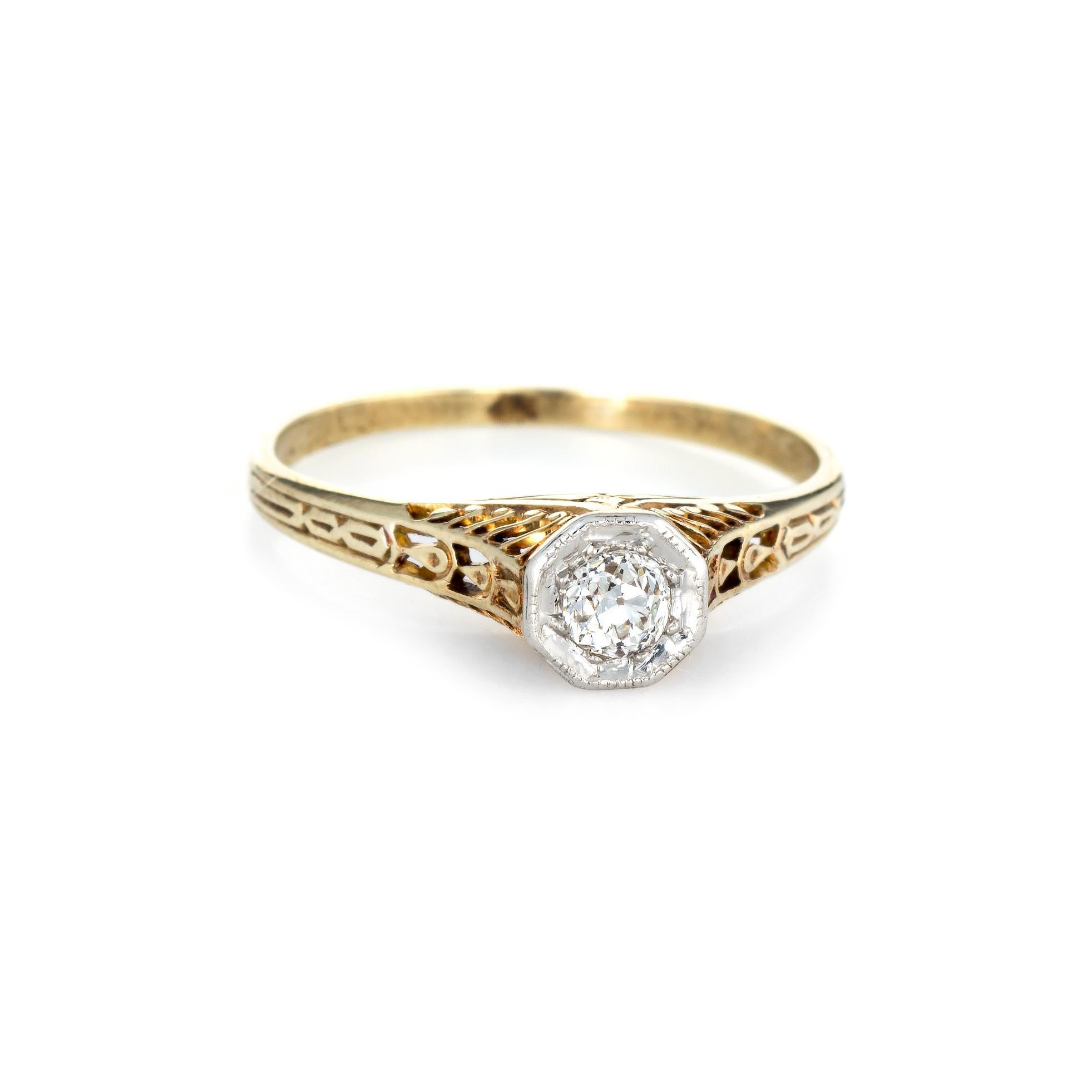 Finely detailed vintage Art Deco era ring (circa 1920s to 1930s) crafted in 14 karat yellow gold. 

Centrally mounted estimated 0.15 carat old mine cut diamond is estimated at I-J color and SI1-2 clarity. 

The ring features scrolled foliate detail