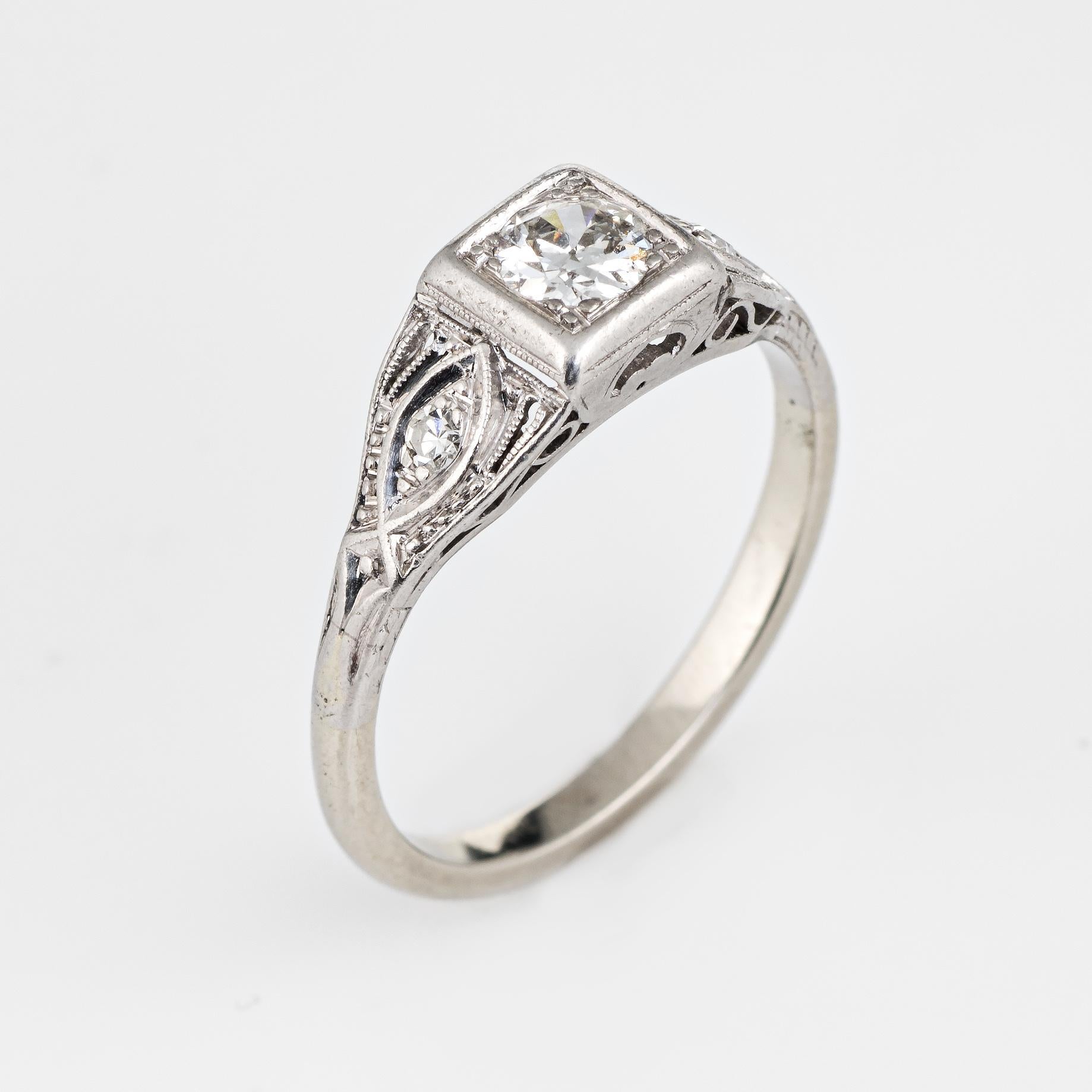 Elegant & finely detailed Art Deco era ring (circa 1920s to 1930s), crafted in 900 platinum & 14k white gold. 

Centrally mounted estimated 0.35 carat old European cut diamond is accented with two estimated 0.01 carat single cut diamonds. The total