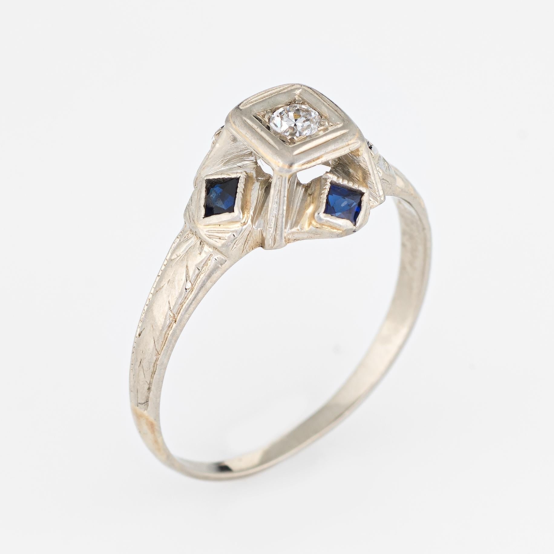 Finely detailed vintage Art Deco era ring (circa 1920s to 1930s) crafted in 20 karat white gold. 

Centrally mounted estimated 0.05 carat old European cut diamond (estimated at H-I color and VS2 clarity). Four French cut sapphires (synthetic) are