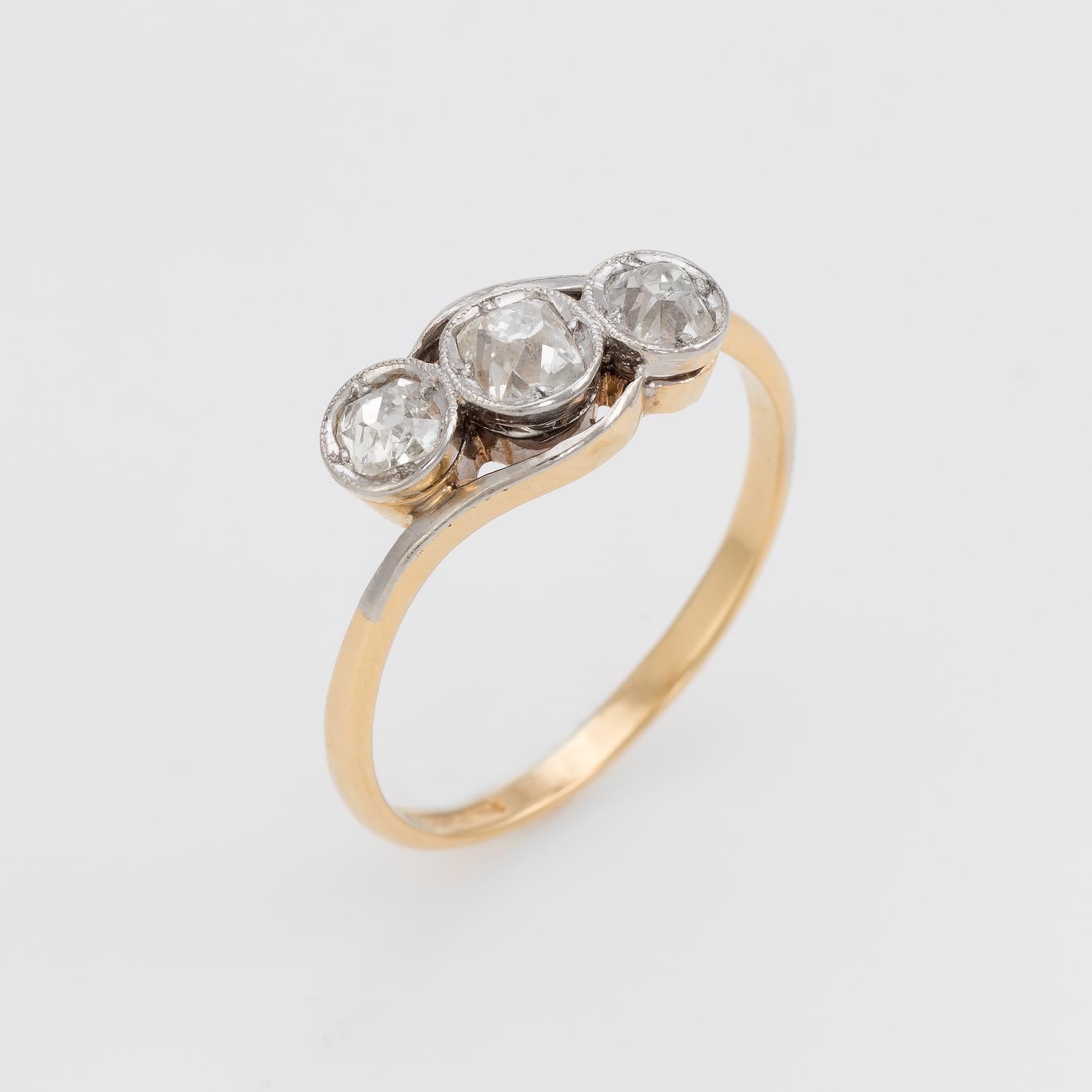 Finely detailed vintage Art Deco era ring (circa 1920s to 1930s), crafted in 18 karat yellow gold and 900 platinum. 

Centrally mounted estimated 0.20 carat old cushion cut diamond is accented with two estimated 0.15 carat old cushion cut diamonds.