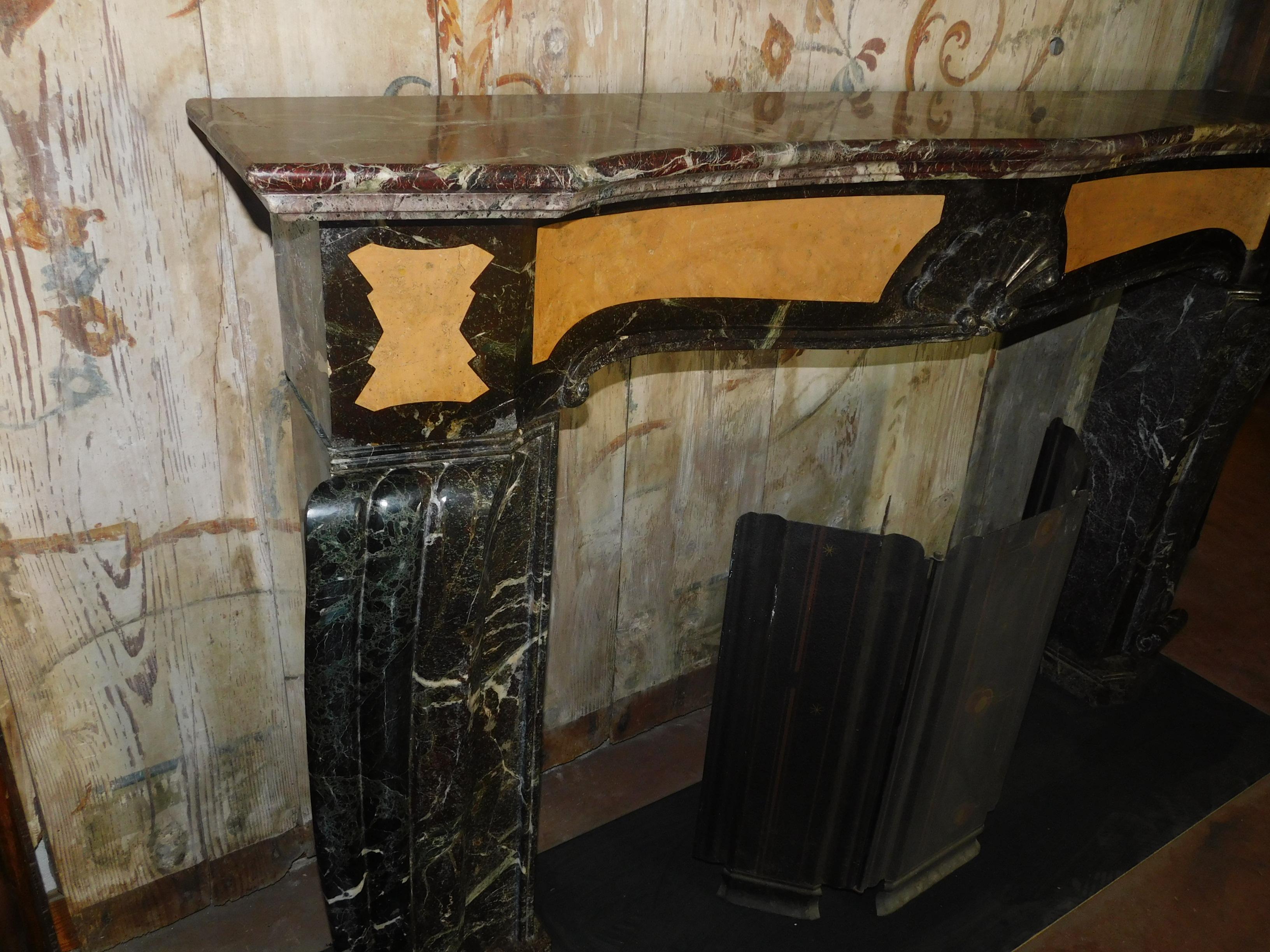 Antique and precious deco fireplace, composed of red (levanto) and yellow (siena) marble inlaid with geometric designs, wavy legs and pediment, well sculpted and ground. Composed of precious and rare marbles, which change yield and color based on
