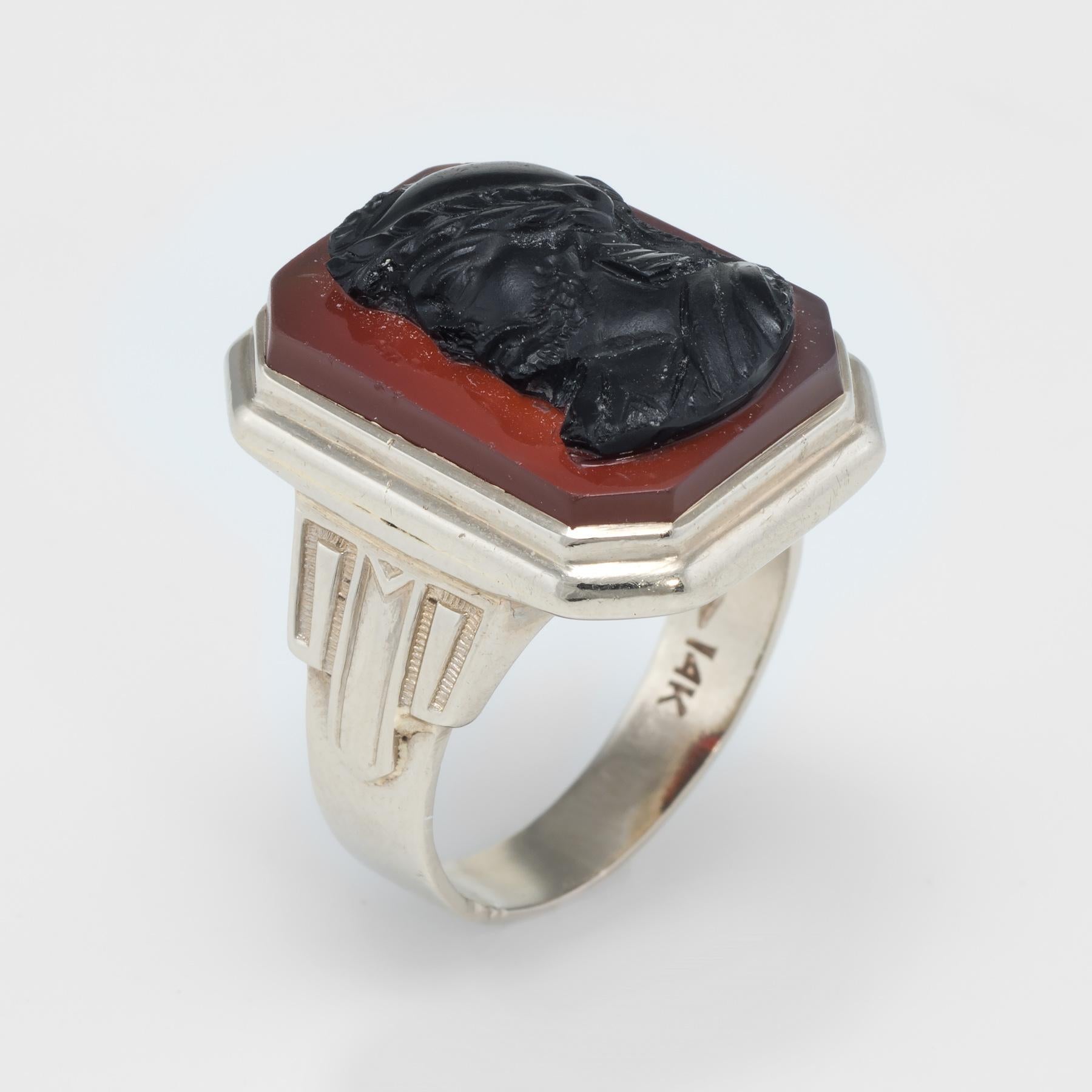 Finely detailed Art Deco era men's ring (circa 1920s to 1930s), crafted in 14 karat white gold. 

Hardstone cameo is carved in the form of a Roman Soldier and measures 18.5mm x 12.5mm. The cameo sits upon a carnelian backdrop that measures 19mm x
