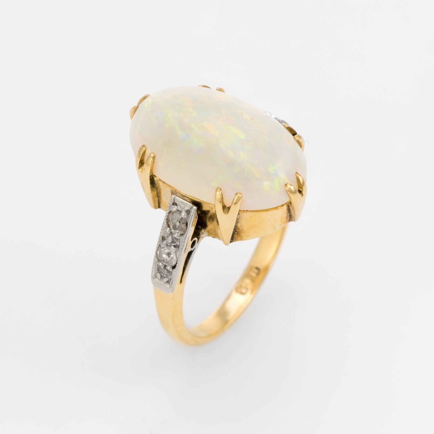 Elegant vintage Art Deco era cocktail ring (circa 1920s to 1930s), crafted in 18 karat yellow gold. 

Centrally mounted cabochon cut natural opal measures 16mm x 10mm (estimated at 7.50 carats), accented with an estimated 0.08 carats of old mine cut
