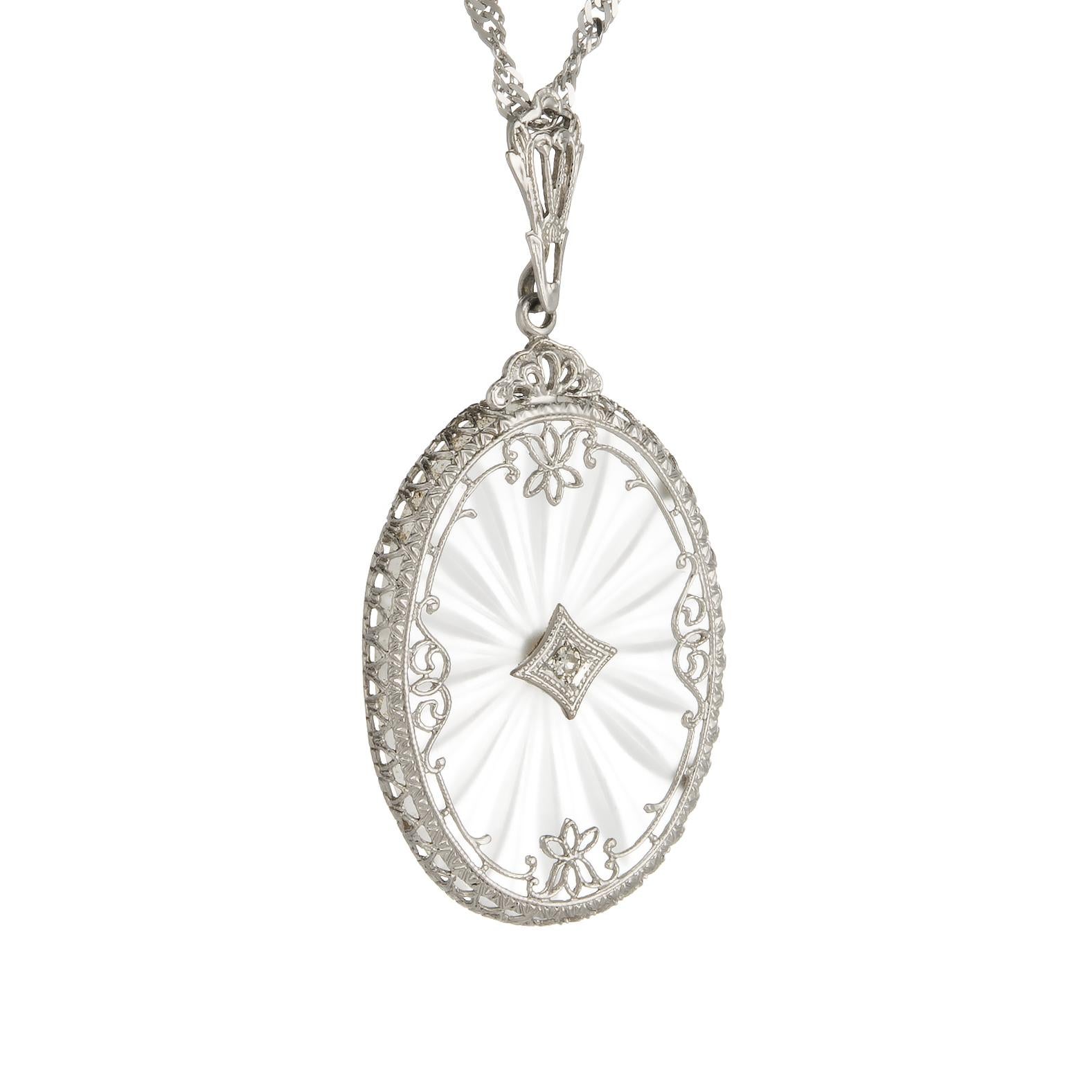 Elegant and finely detailed Art Deco era necklace (circa 1920s to 1930s), crafted in 14 karat white gold.  

Rock crystal is oval cut measuring 23mm x 16mm, accented with an estimated 0.01 carat single cut diamond (estimated at K-L color and SI1