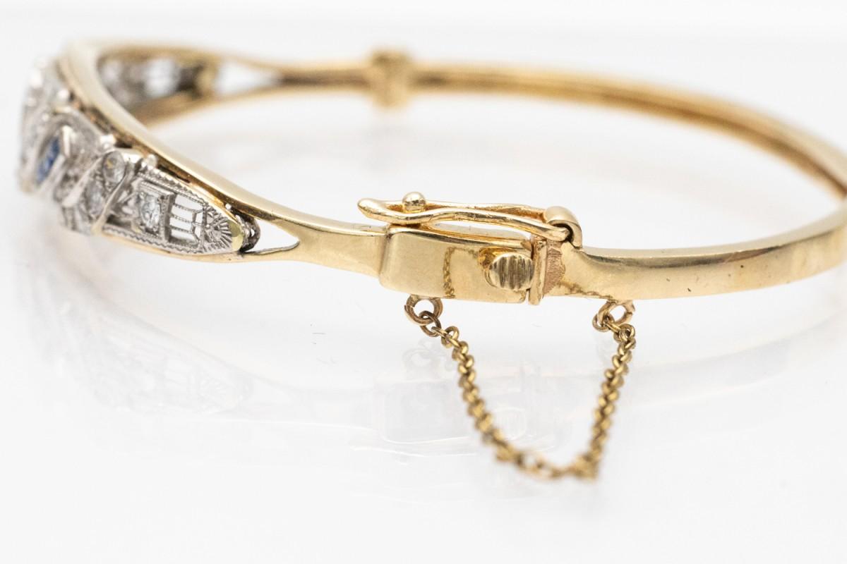 Precioso brazalete rígido conservado en el estilo geométrico de la transición entre el Art Nouveau y el Art Déco. De oro amarillo de 0,560 quilates aprox. y elementos de platino, decorado con diamantes talla brillante antiguo con un peso total de