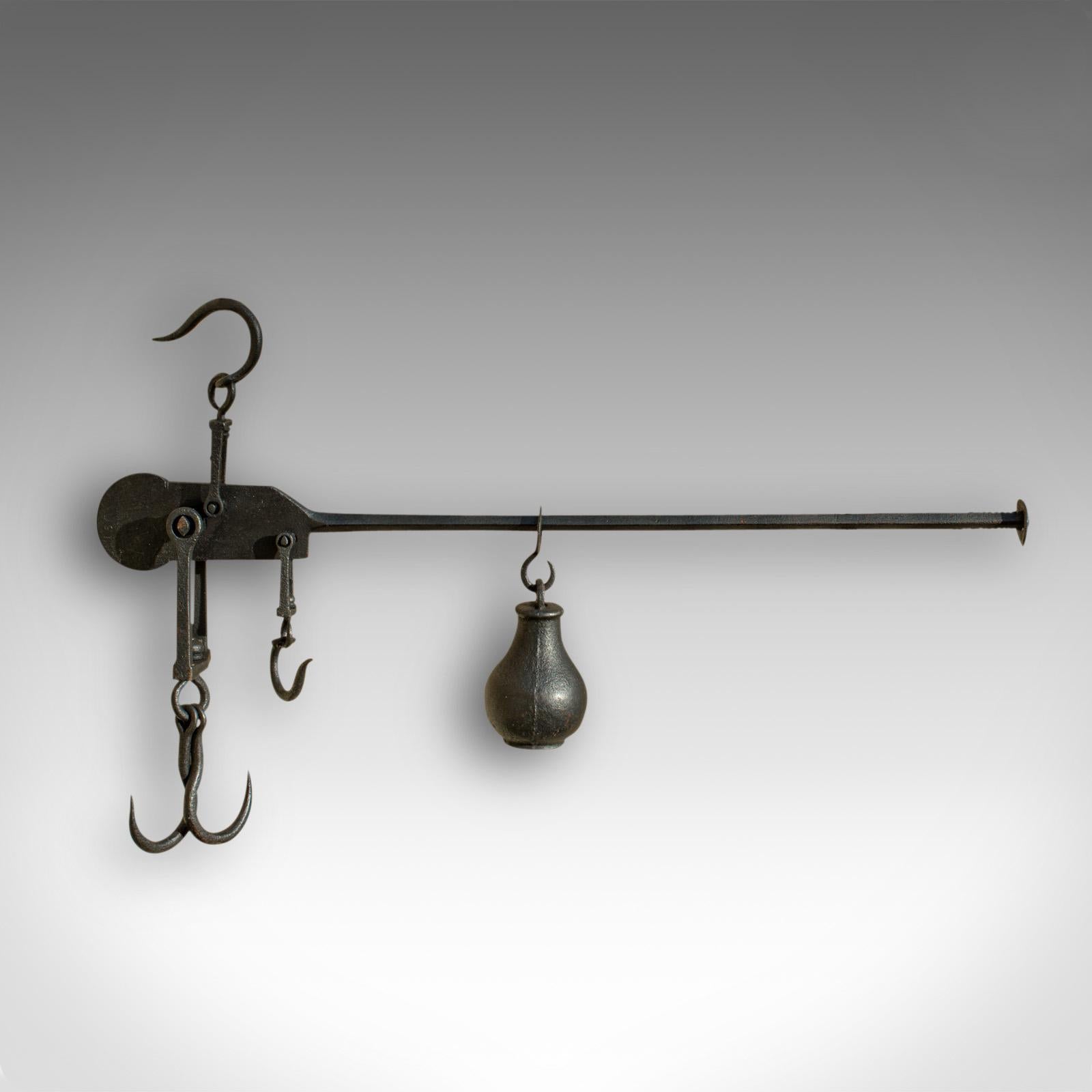 This is an antique decorative butcher's steelyard. An English, cast iron weighing instrument, dating to the late 18th century, circa 1800.

Decorative hanging piece with countryside appeal
Displays a desirable aged patina
Cast iron presented