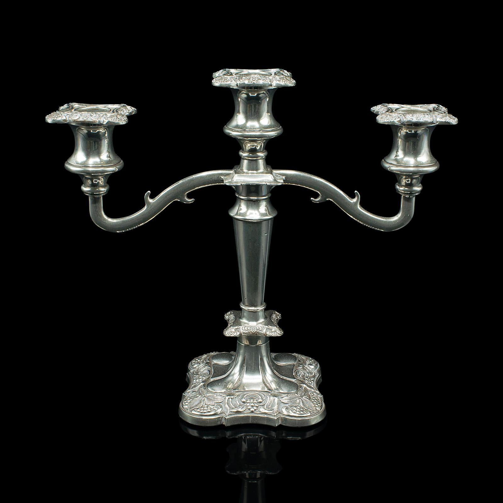 Il s'agit d'un candélabre décoratif ancien. Pièce maîtresse anglaise à trois branches, en métal argenté, datant de la fin de la période victorienne, vers 1900.

Pièce maîtresse attrayante de la fin de l'époque victorienne, avec des détails fins et
