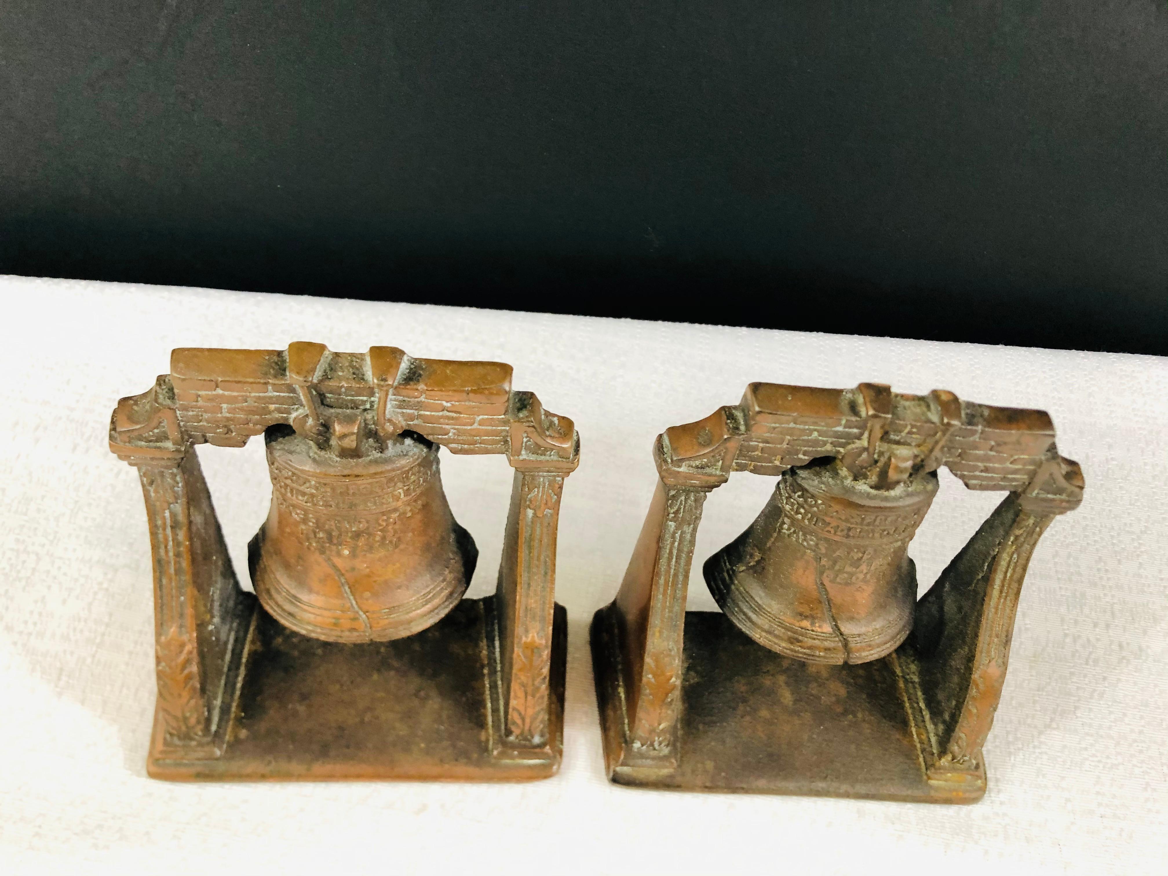 A decorative set of two antique cast bronze Mission bells sculptures. Each bell features fine details and engraving. 

Perfect to decorate your desk, study room or your living room shelves. 

Measures: 4.75