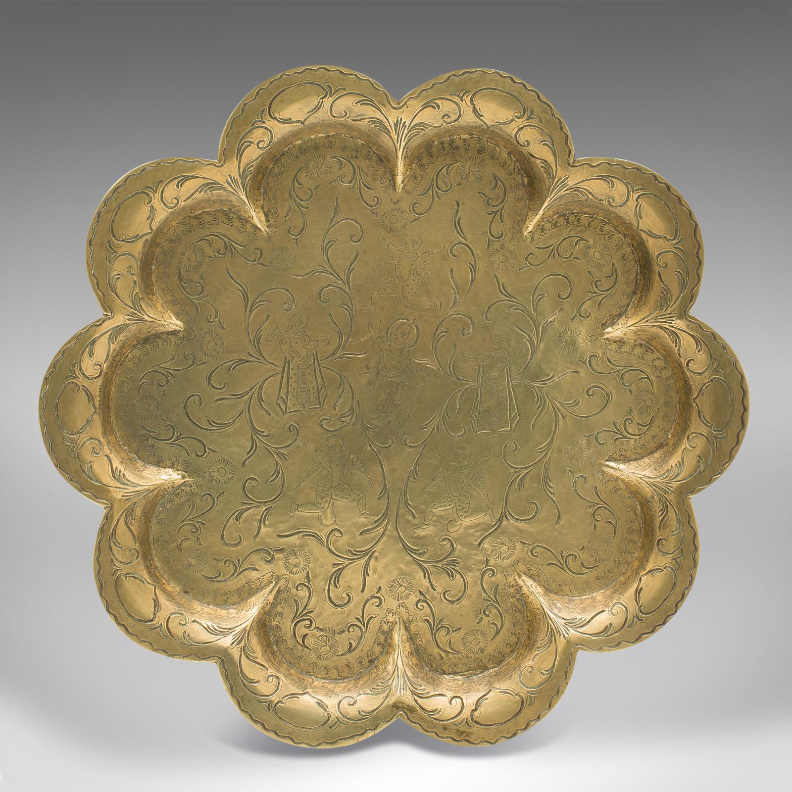 This is an antique decorative charger. An Indian, brass decagon dished plate with fine engraved detail, dating to the late Victorian period, circa 1880.

Fascinating foliate form with great colour and decorative finish
Displays a desirable aged