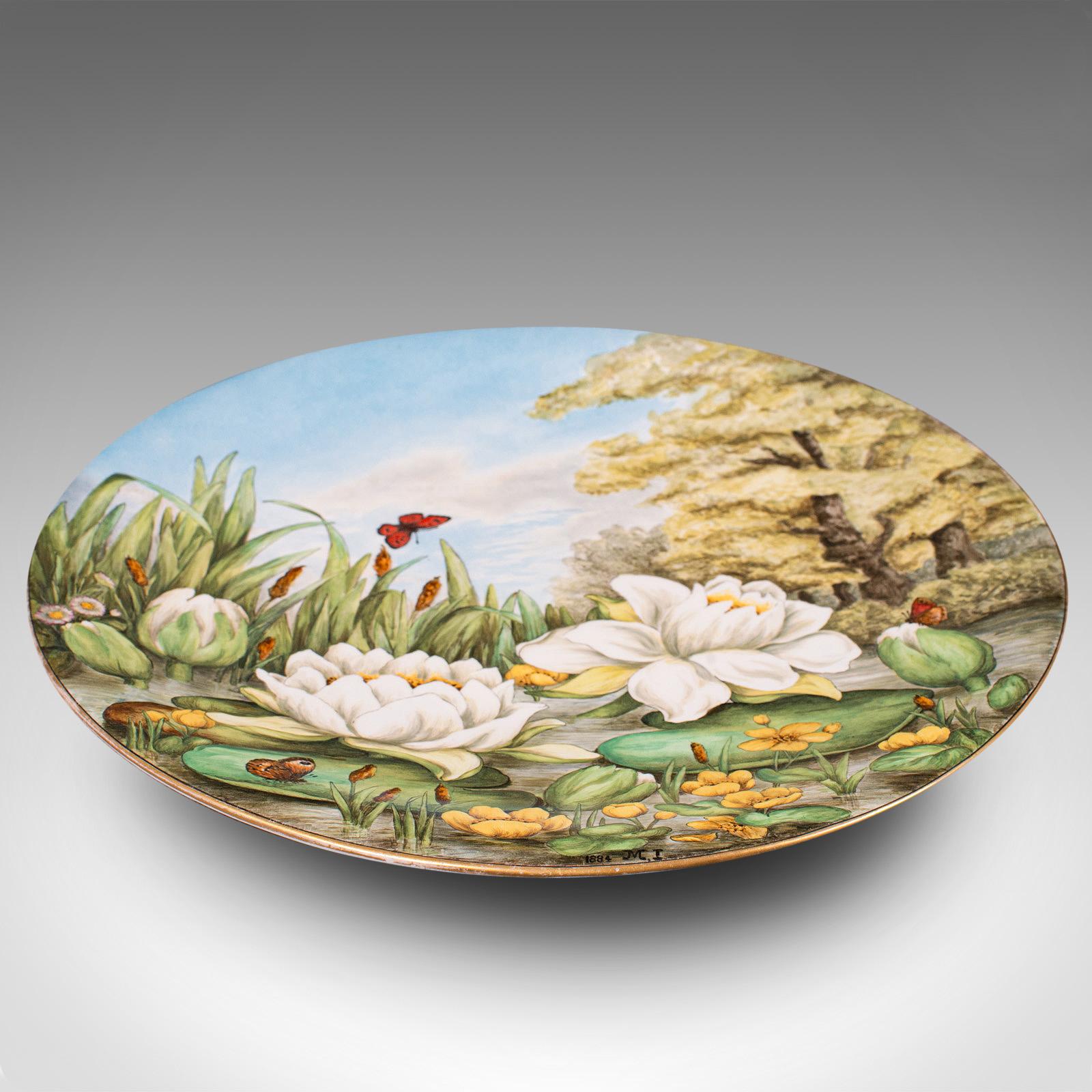 This is an antique decorative charger plate. An English, ceramic hand-painted dish in Art Nouveau taste, from the Victorian period, dated 1884.

Delightfully decorated plate, suitable as a centrepiece or wall mounted
Displays a desirable aged