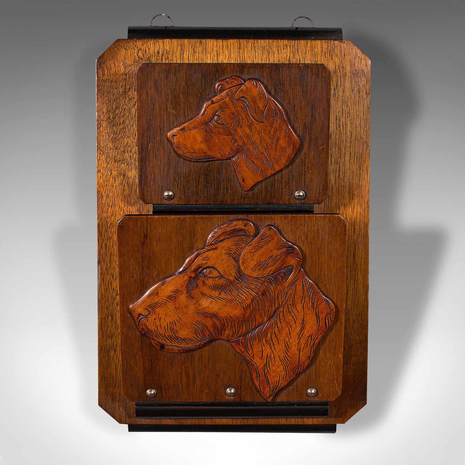 This is an antique decorative dog letter rack. An English, mahogany and oak wall hanging post tidy, dating to the Edwardian period, circa 1910.

Decorated rack with a fascinating study of a hound as a pup and adult
Displays a desirable aged