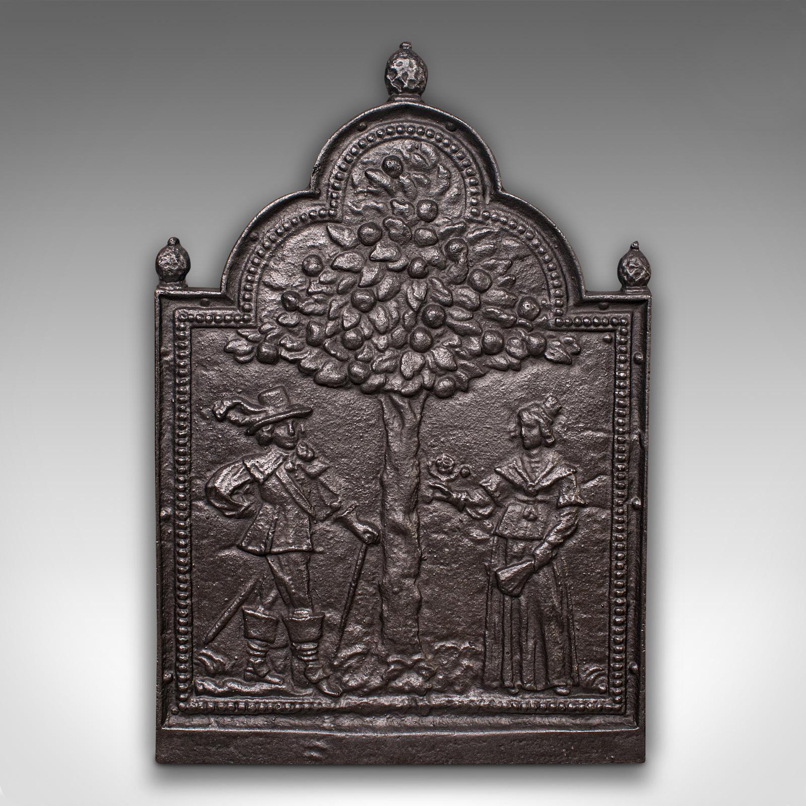 This is an antique decorative fire back. An English, cast iron fireplace hearth backrest with Tree of Life scene, dating to the late Victorian period, circa 1900.

Pleasingly cast with a pair of figures and Tree of Life motif
Displays a desirable