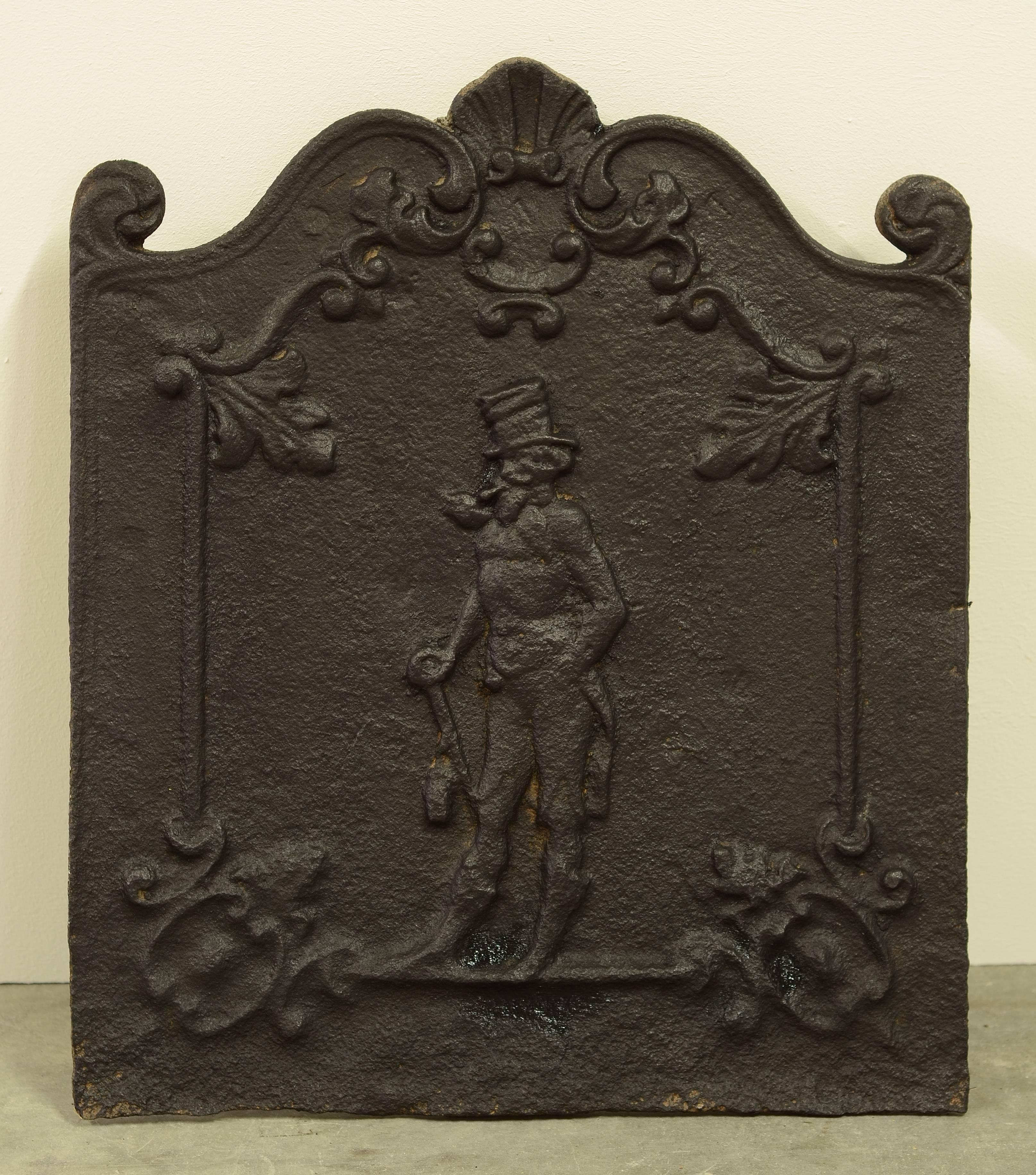 Little cast iron fireback showing a man with a top hat, very decorative.

Excellent condition, can be used in a fireplace or as a backsplash.
 
