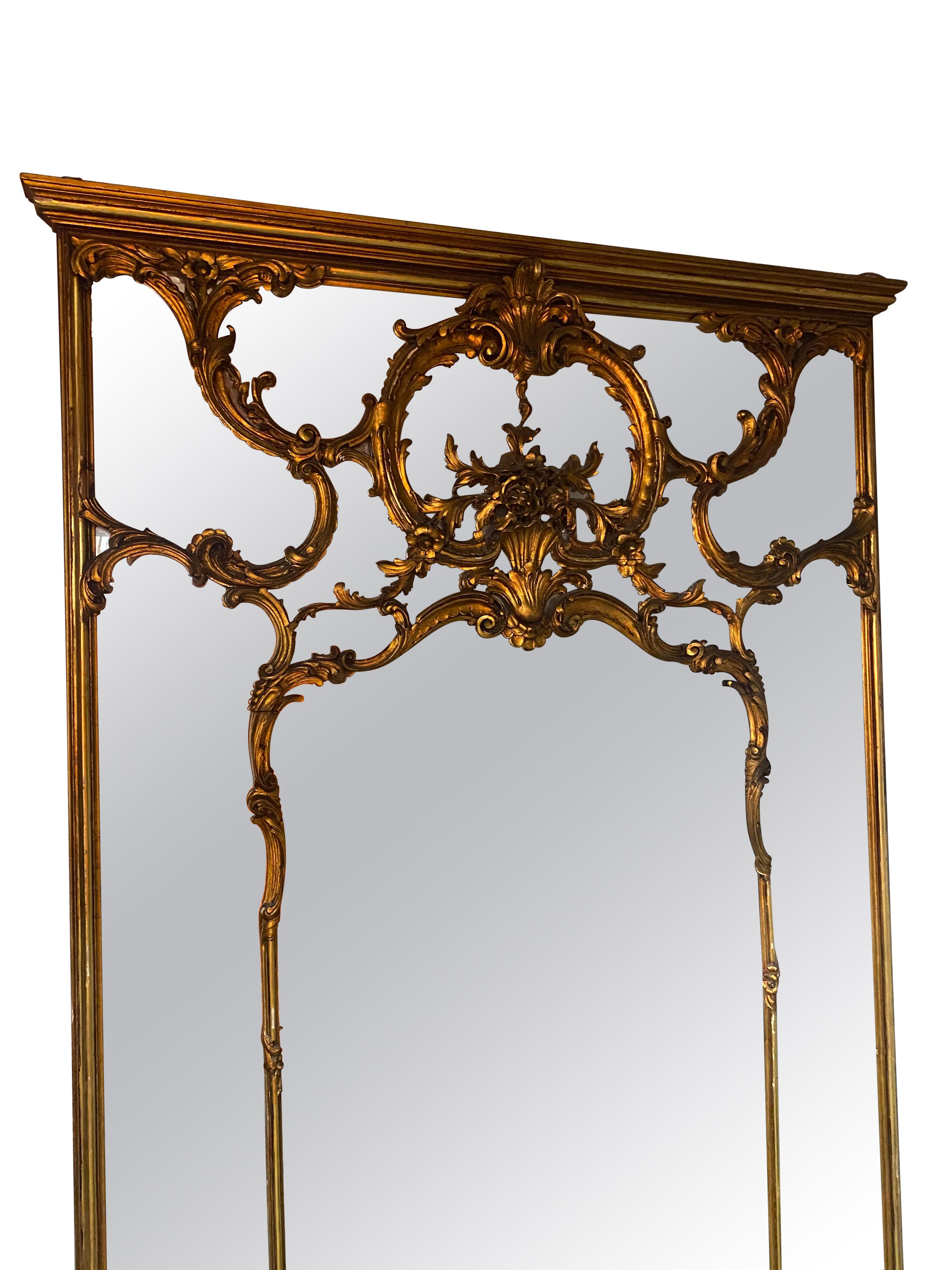 Antique full length gold decorative mirror in the style of Louis XVI. Slight age showing in some of the mirror adding to the character. 
A beautiful piece that would compliment any grand room or hallway. The slightly aged glass is decorated with