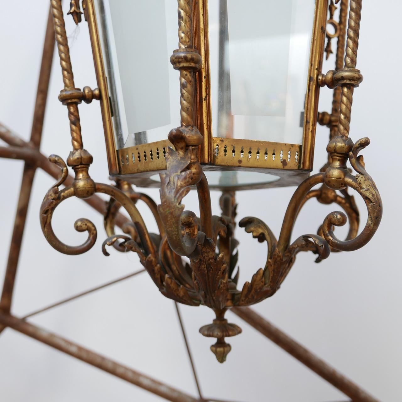 A decorative antique lantern.

Dutch, circa 1900.

The decorative ceiling rose and chain were retained, the rose being particularly attractive.

Etched glass sides (two are later replacements).

One decorative finial above the glass lacking