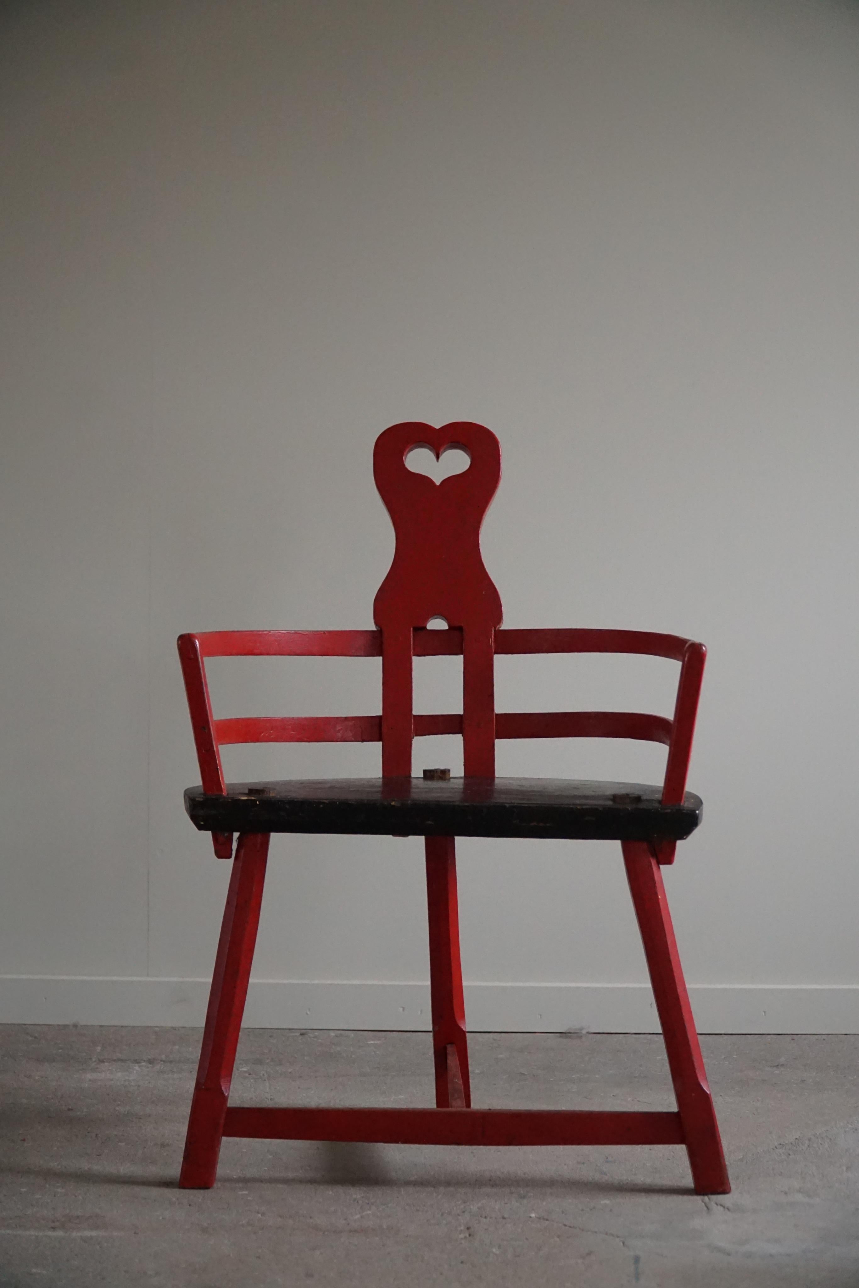 Ein so eleganter und dekorativer antiker Herzstuhl mit interessanten Formen. Ein seltenes Dekorationsobjekt aus Holz, rot bemalt und mit einem Herz in der Kopfstütze. Hergestellt von einem Tischler in Schweden um 1900-1920. Ein echtes