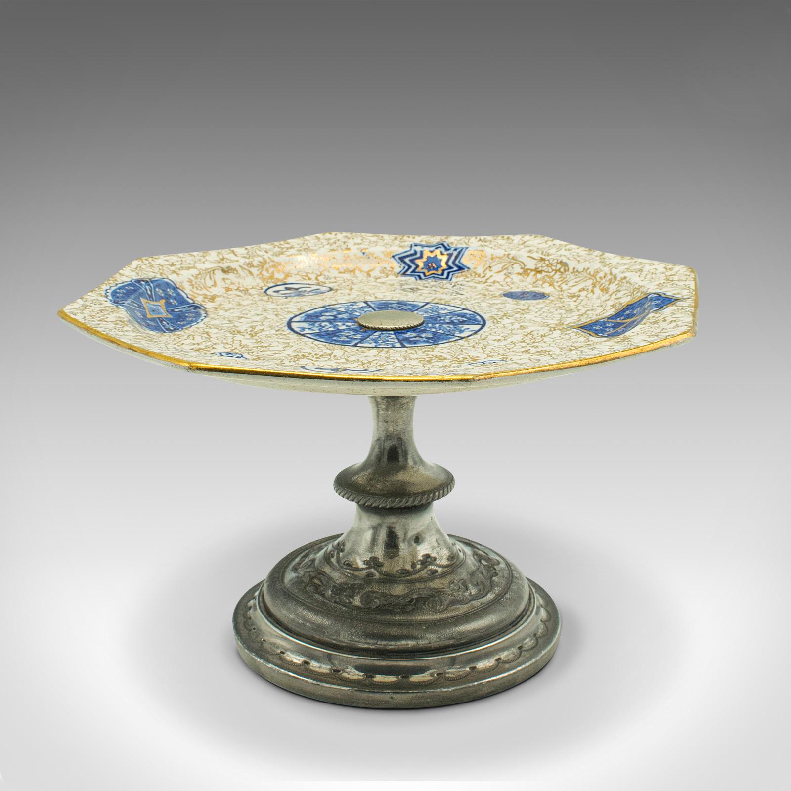 This is an antique decorative serving set. An English, ceramic cake Stand and bon bon dish, dating to the early 20th century, circa 1920.

Pleasingly decorative pieces, with profuse patterns and gilt tonality
Displaying a desirable aged patina