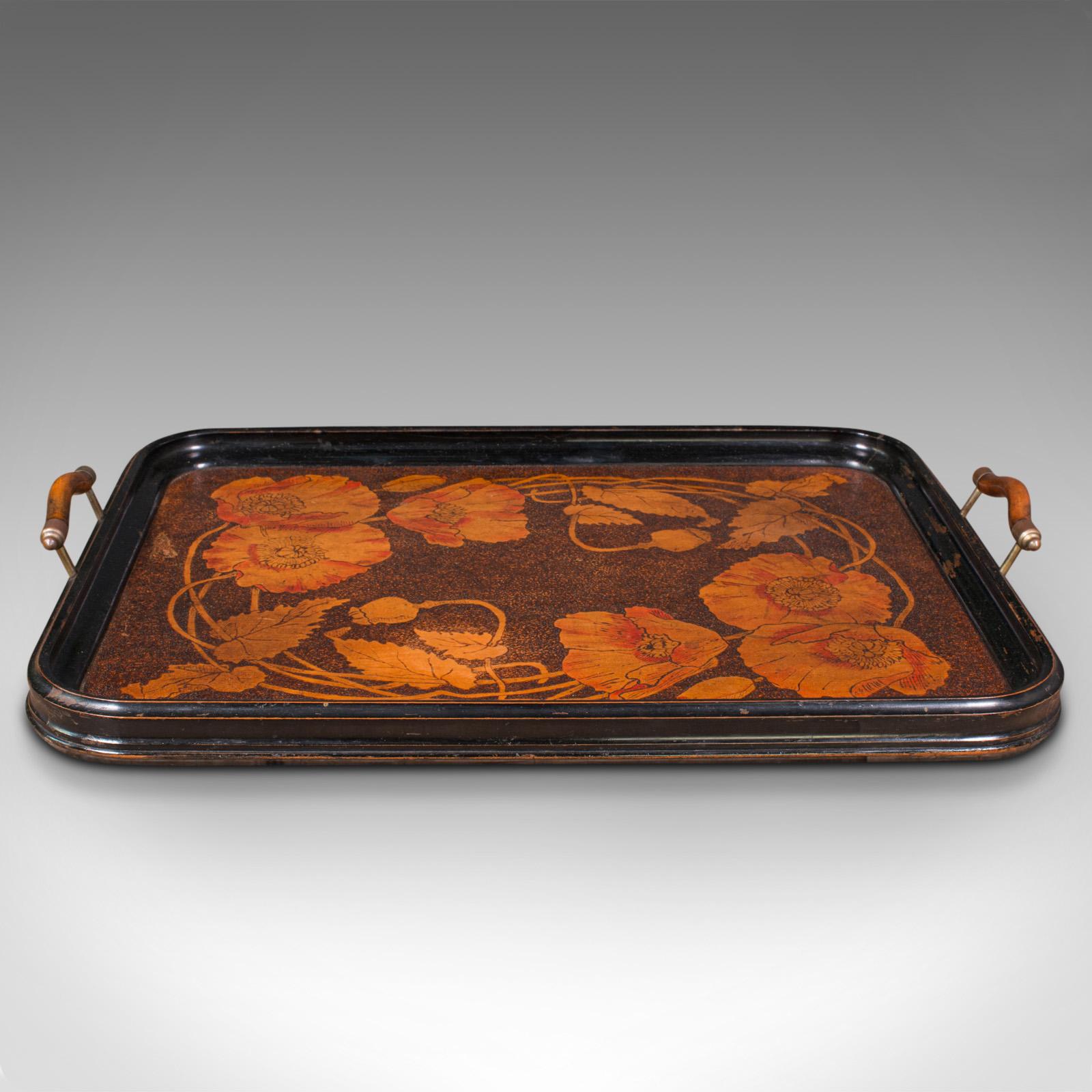 This is an antique decorative serving tray. An English, beech and mahogany tray with hand-finished detail in the Art Nouveau taste, dated to the late Edwardian period, 1909.

Appealing example of Art Nouveau with eye-catching finish
Displays a