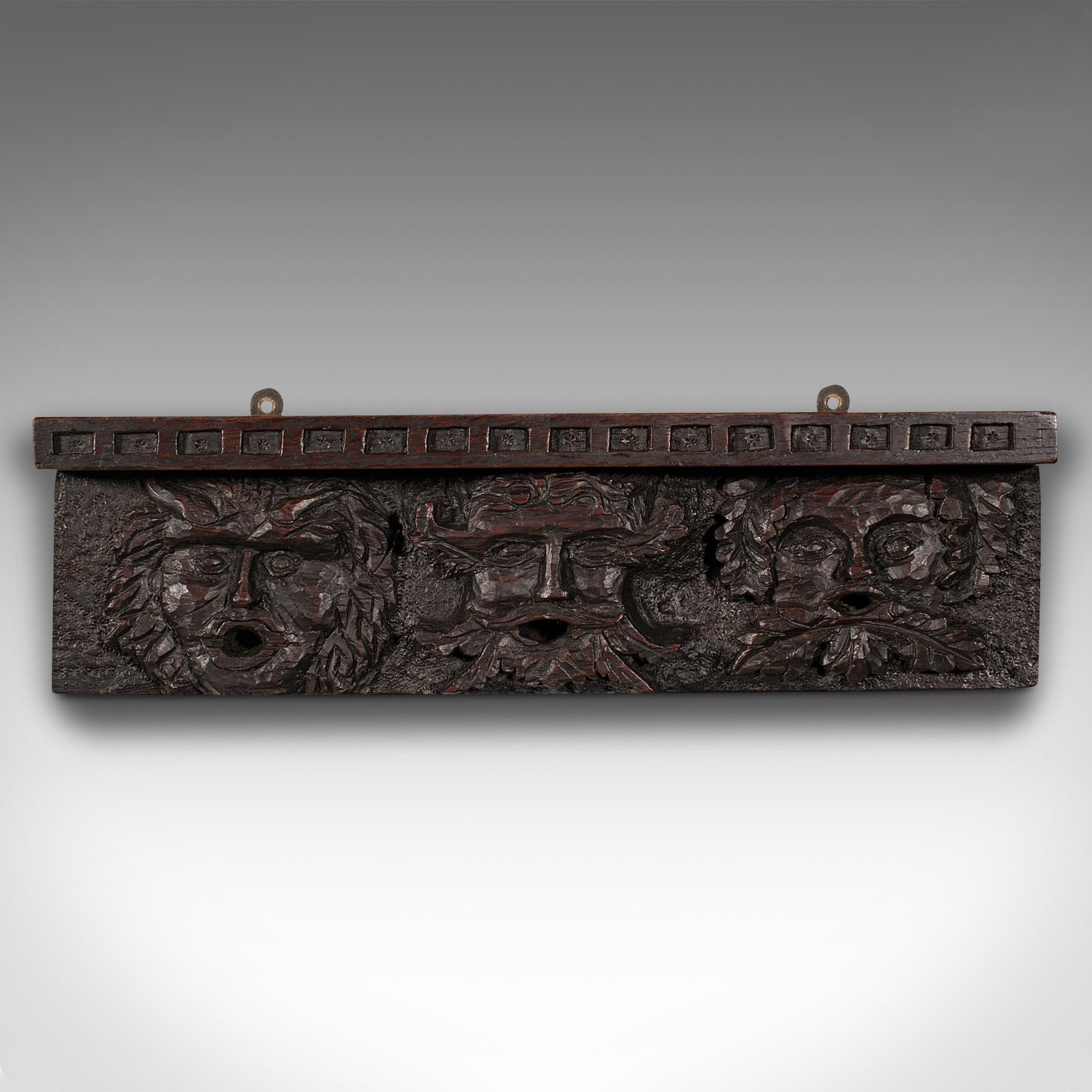 This is an antique decorative wall bracket. An English, carved oak frieze with green man masques in Gothic taste, dating to the Victorian period, circa 1880.

Striking carvings with a trio of mythological portraits
Displays a desirable aged