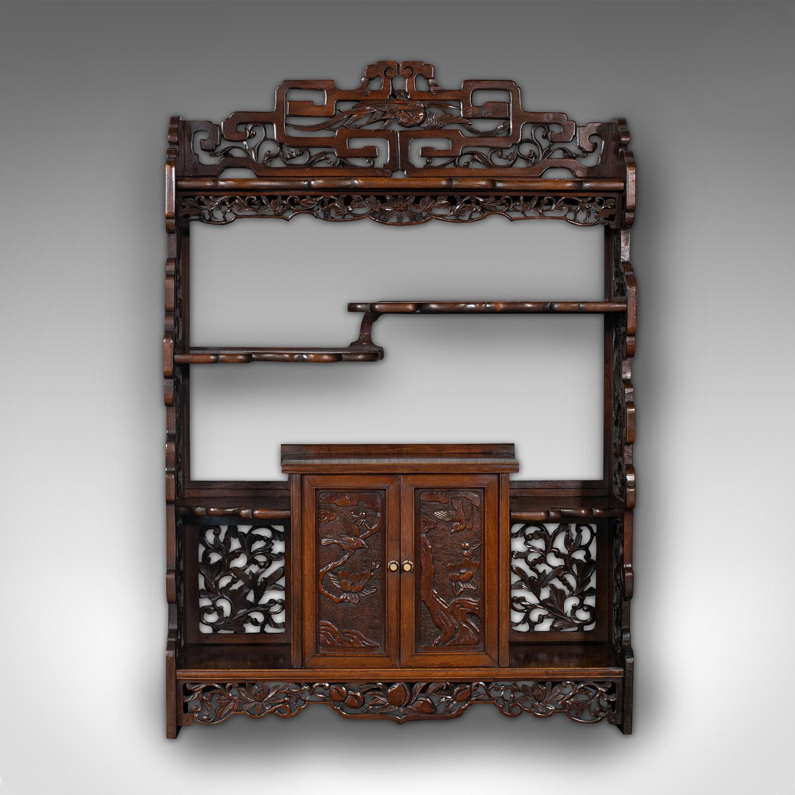 This is an antique decorative whatnot. A Chinese, mahogany hanging wall shelf with asymmetric form, dating to the late Victorian period, circa 1900.

A treat of fretwork, unusual Kazaridana form and carved detail
Displays a desirable aged patina