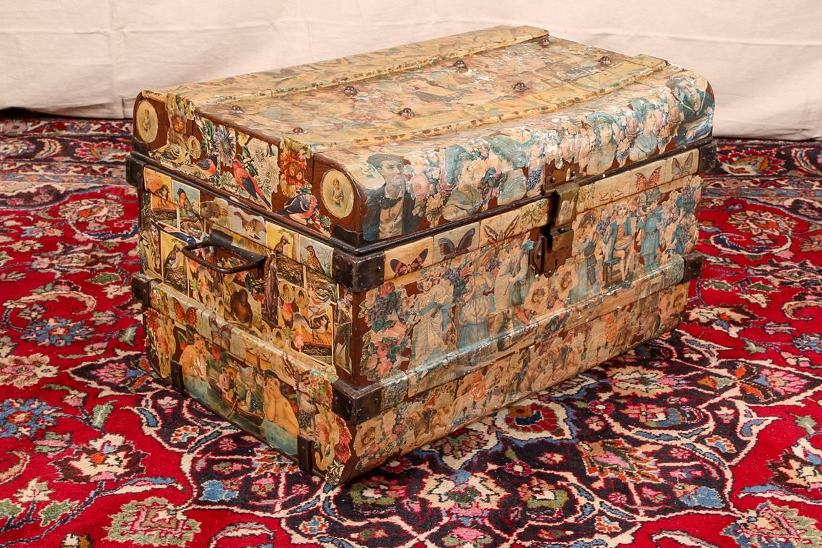 Antike Decoupage-Truhe:: Metall:: mit allseitig aufgeklebten viktorianischen Figurenschildern verziert:: innen rot lackiert. 

Zustand: Erwartete Abnutzung und Gebrauchsspuren:: einschließlich einiger Kratzer an der Oberfläche:: Risse an der Delle::