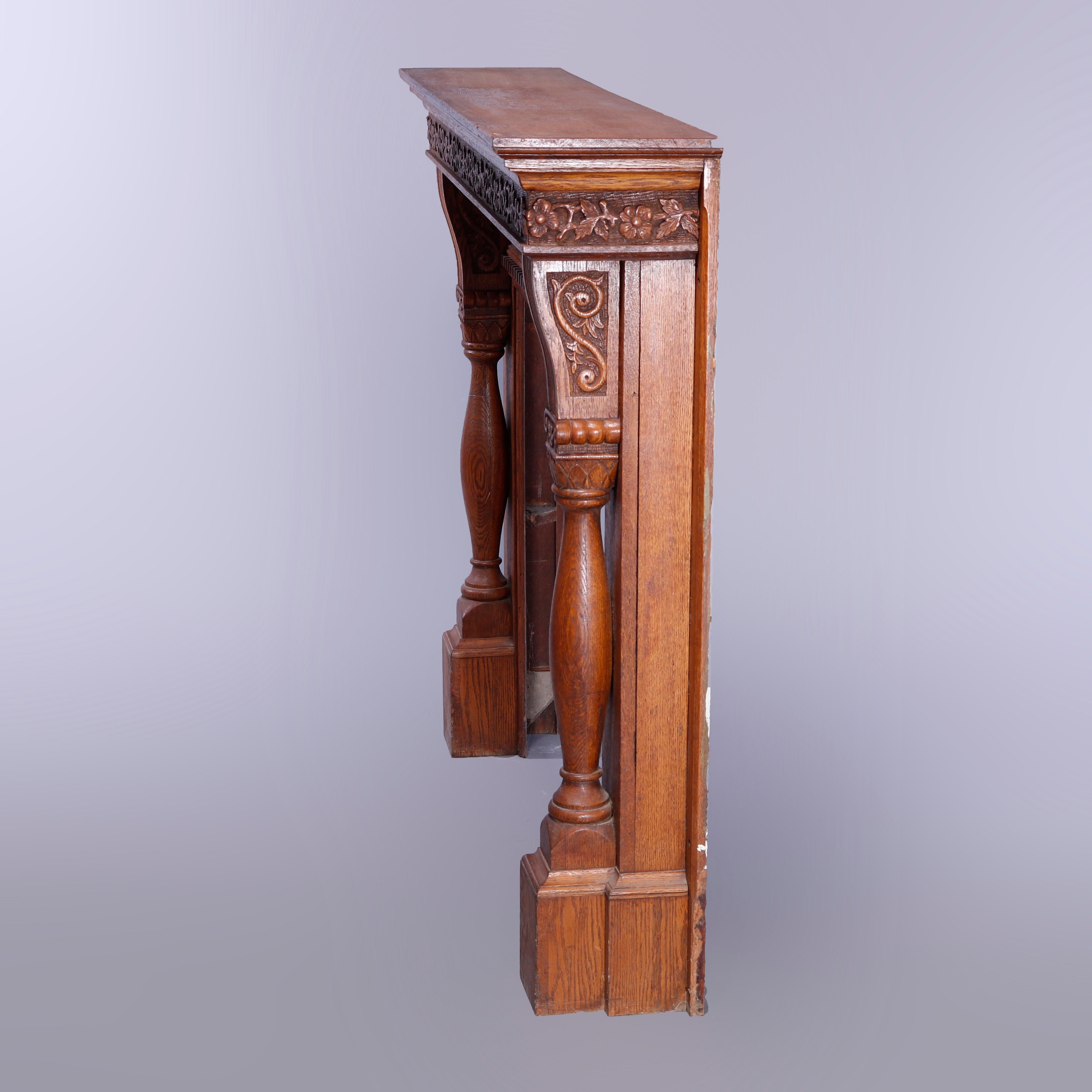 An antique fireplace mantel in the manner of R.J. Horner offers oak construction with deeply carved foliate and scroll elements and having flanking full and turned column supports, c1900

Measures: 52